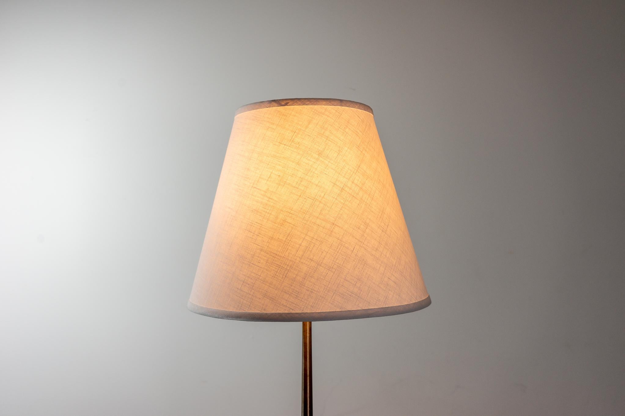 Rosewood and metal Danish floor lamp, circa 1960's. Custom quality shade, tri-light fixture allows user to adjust the brightness level. New wiring. 

Please inquire for remote and international shipping rates.