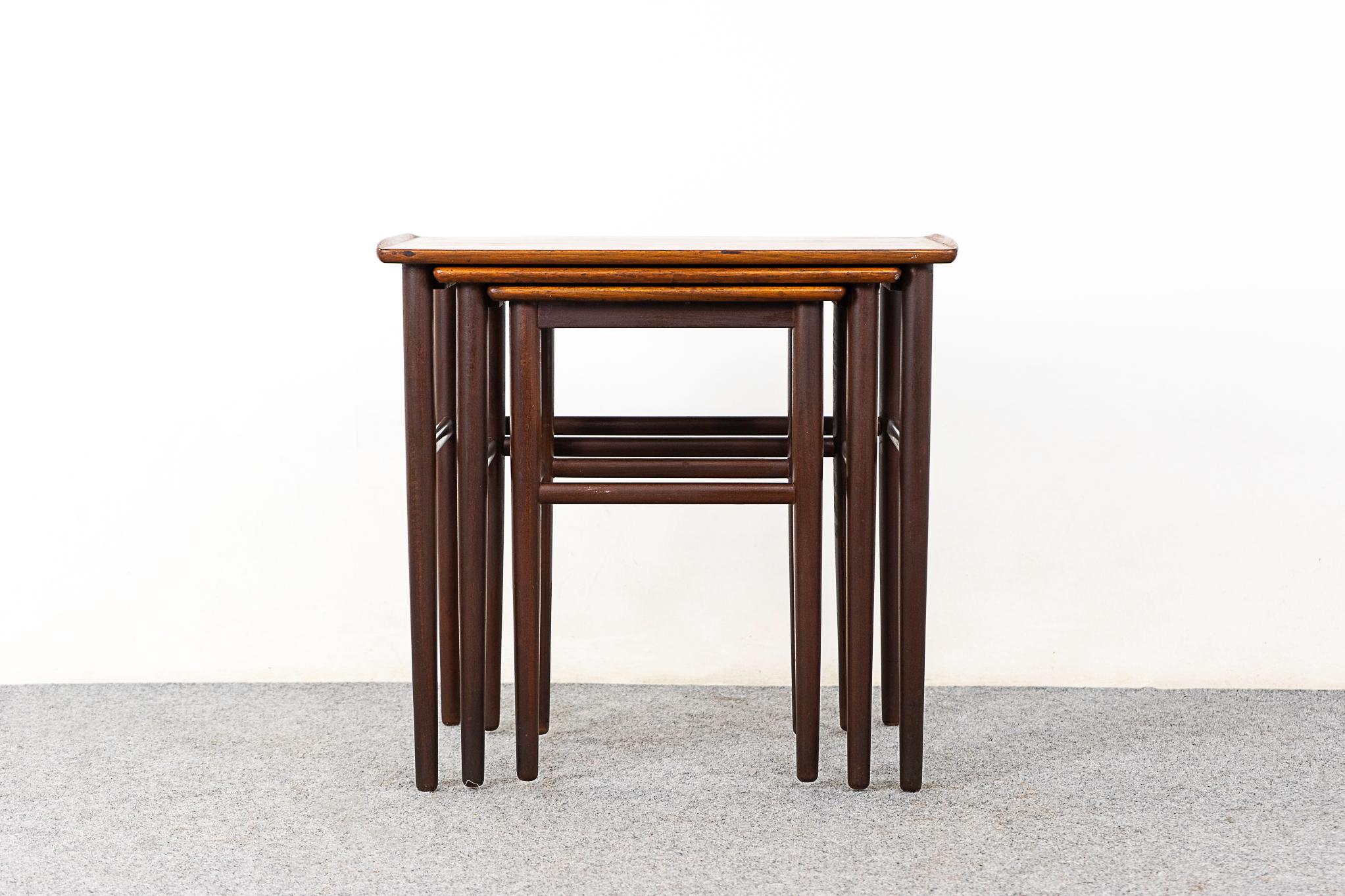 Rosewood nesting tables, circa 1960's. Gently curved edges add a touch of softness to the crisp, clean, minimalist lines. Compact space saving design with ample surfaces for serving or displaying.

Unrestored item, some marks consistent with
