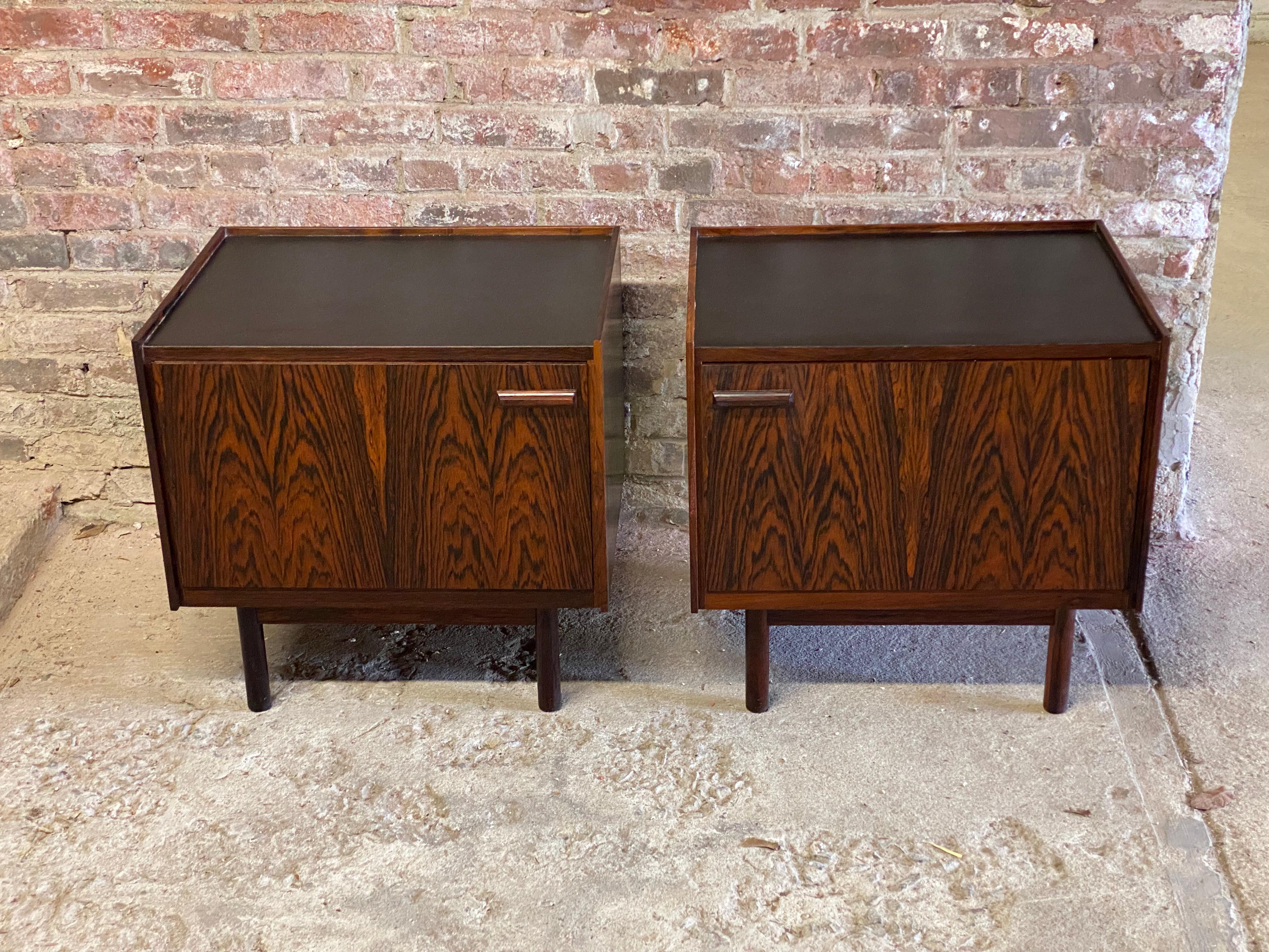 A fine pair of rosewood and black laminate Danish Modern night stands. Beautifully figured veneered cases with solid rosewood legs and handles. Light wood interiors with a removable shelf. Removable legs. One example bares the black enamel Danish