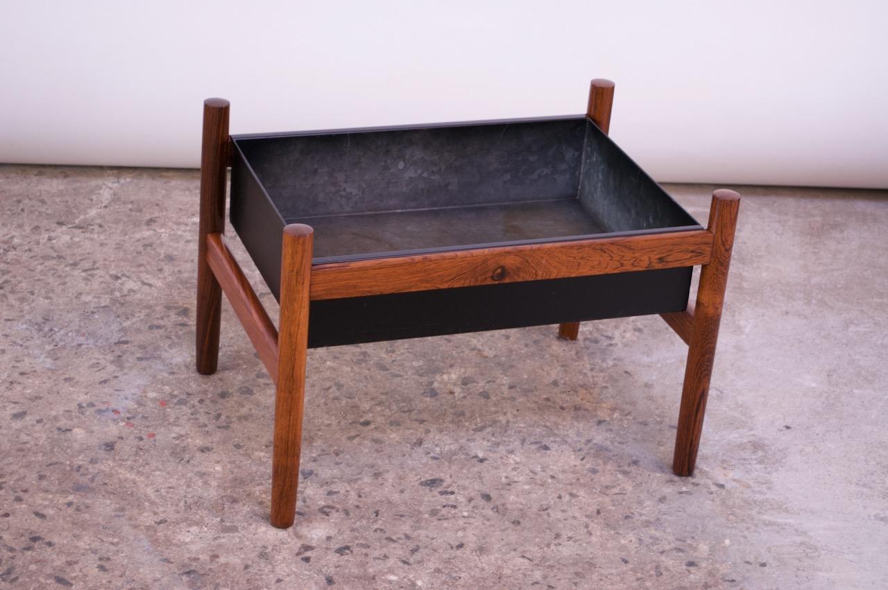 Danish modern planter by Spøttrup featuring the original black metal insert supported by a rosewood base, circa 1960s. Metal interior shows surface wear / rings from use. Rosewood remains original and is in excellent shape.
 
