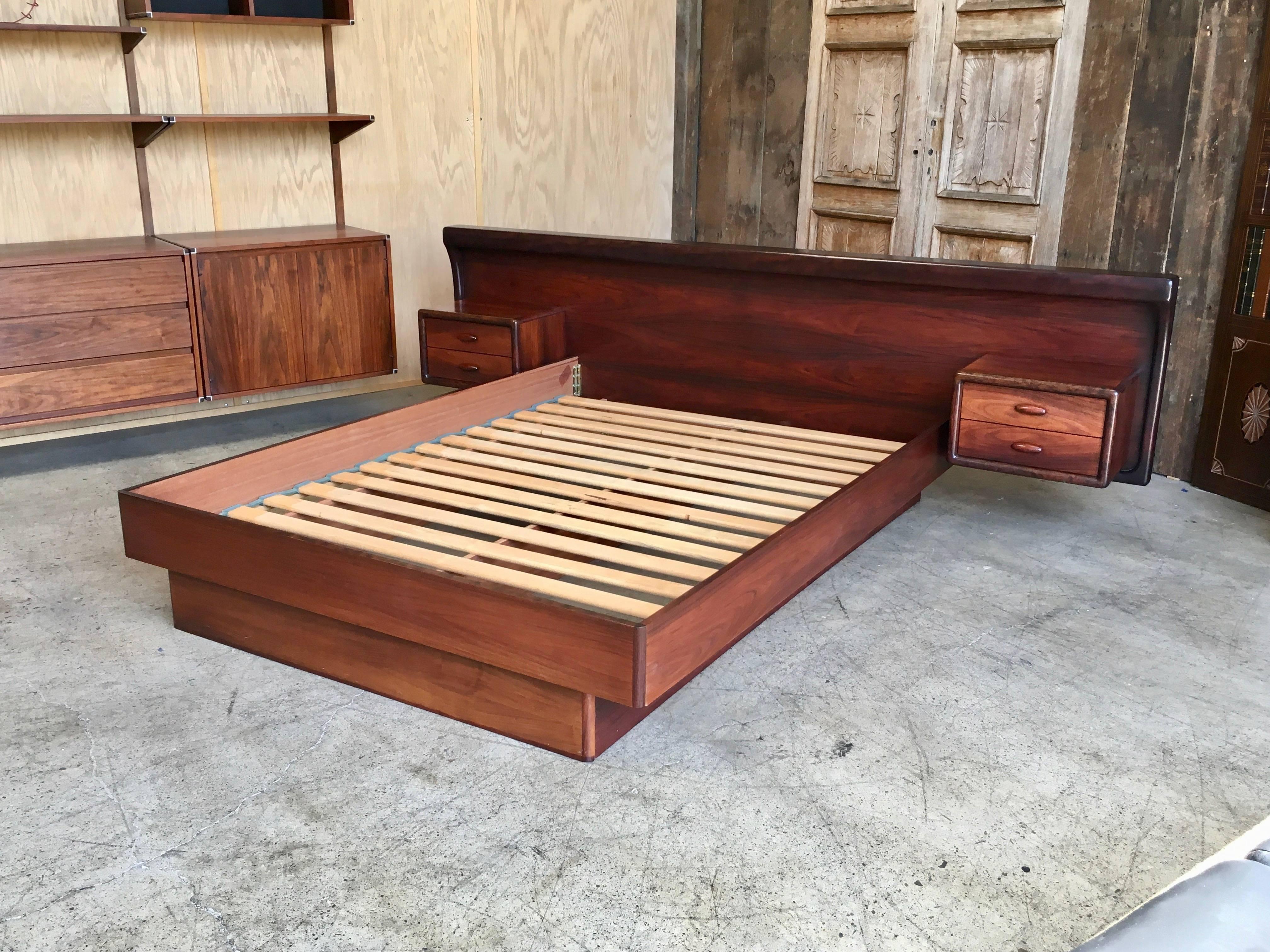 Made by Dyrlund of Denmark this frame holds a queen size mattress surrounded by rich rosewood with a floating nightstand on each side.