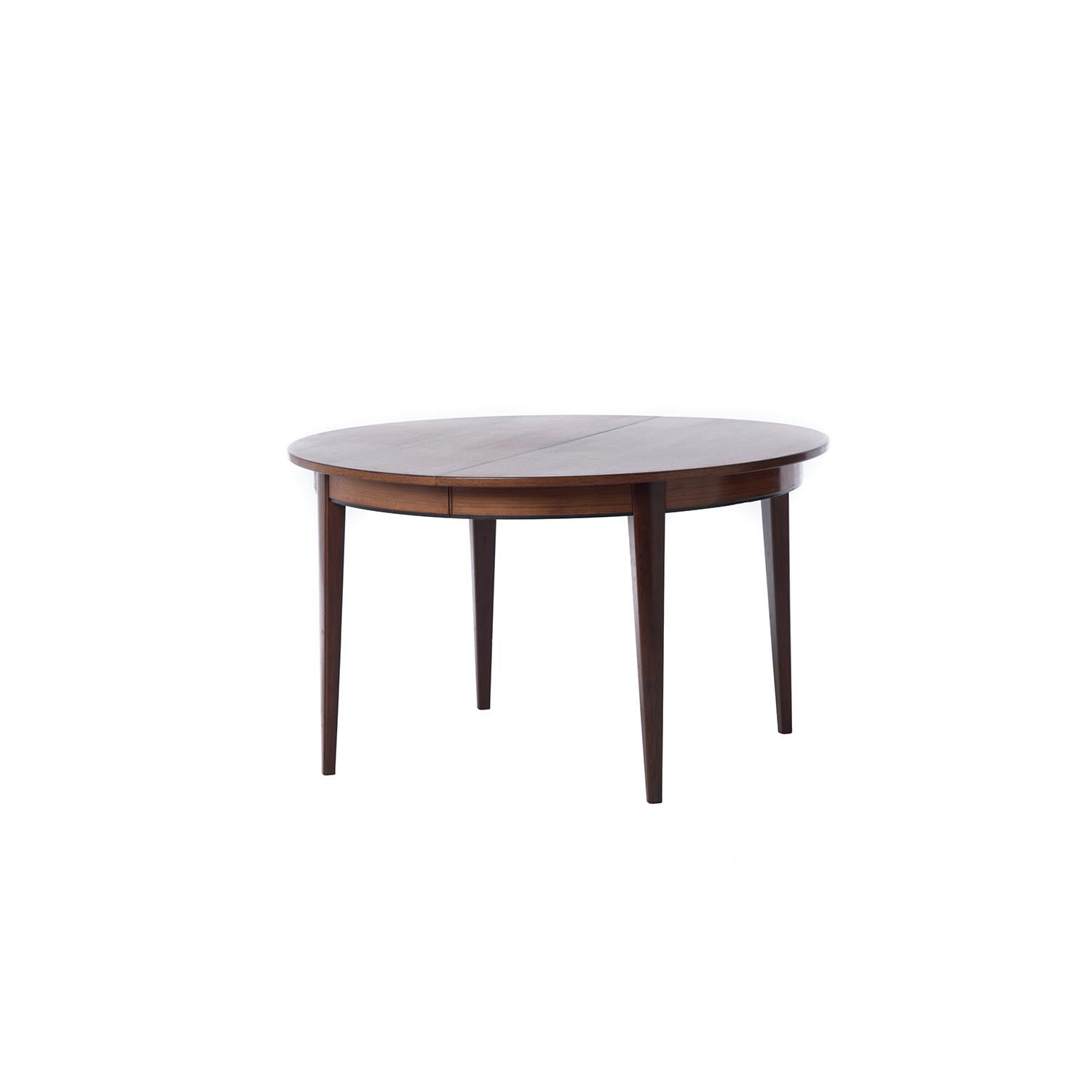 This beautiful and sturdy Danish modern original table is made from highly figured old growth rosewood which has an updated (new) lacquer finish for ease of use. This table comfortably seats four in its smallest iteration, 6 with one leaf and 8 (or