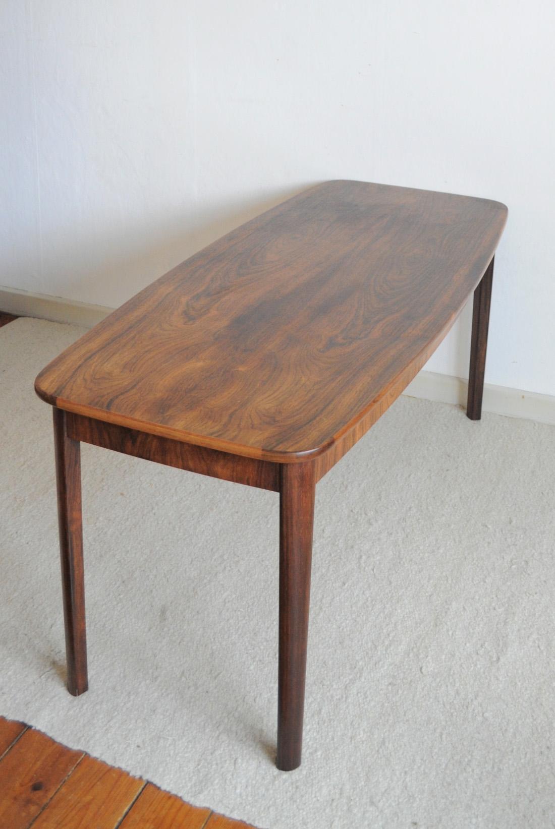 Rosewood veneer and solid side table, excellent craftsmanship. 
Good vintage condition, signs of wear consistent with age and use.

Dimensions (W x D x H): 129.5 x 57/47 x 57.5 cm.