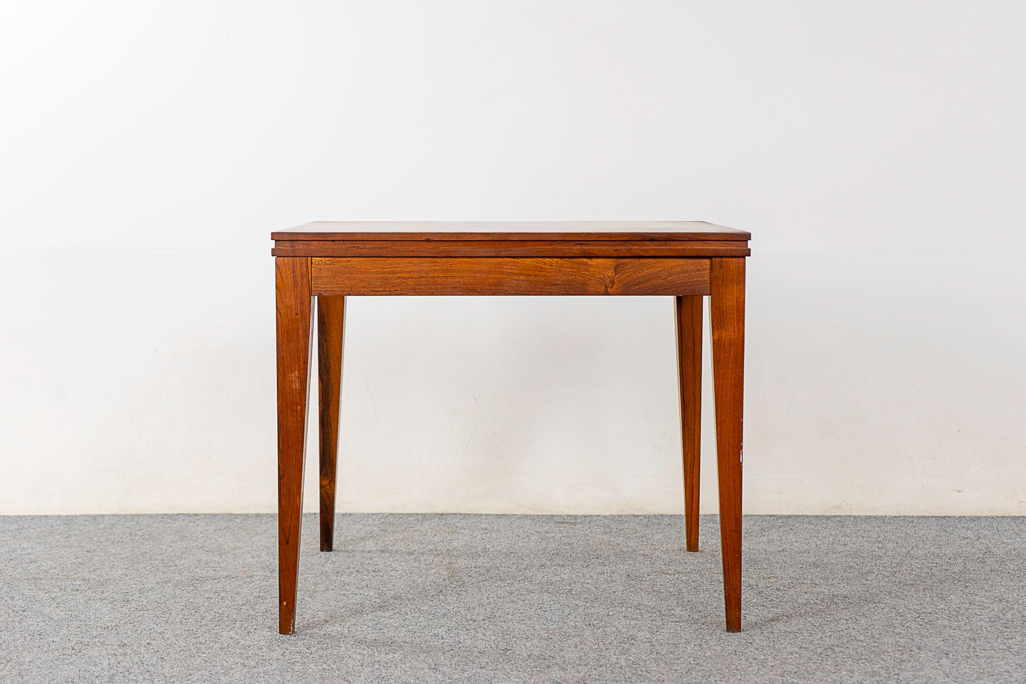 Rosewood mid-century side table, circa 1960's. Compact, highly functional table with slender tapering legs. Pairs perfectly with large sofas!  

Unrestored item, some marks consistent with age.