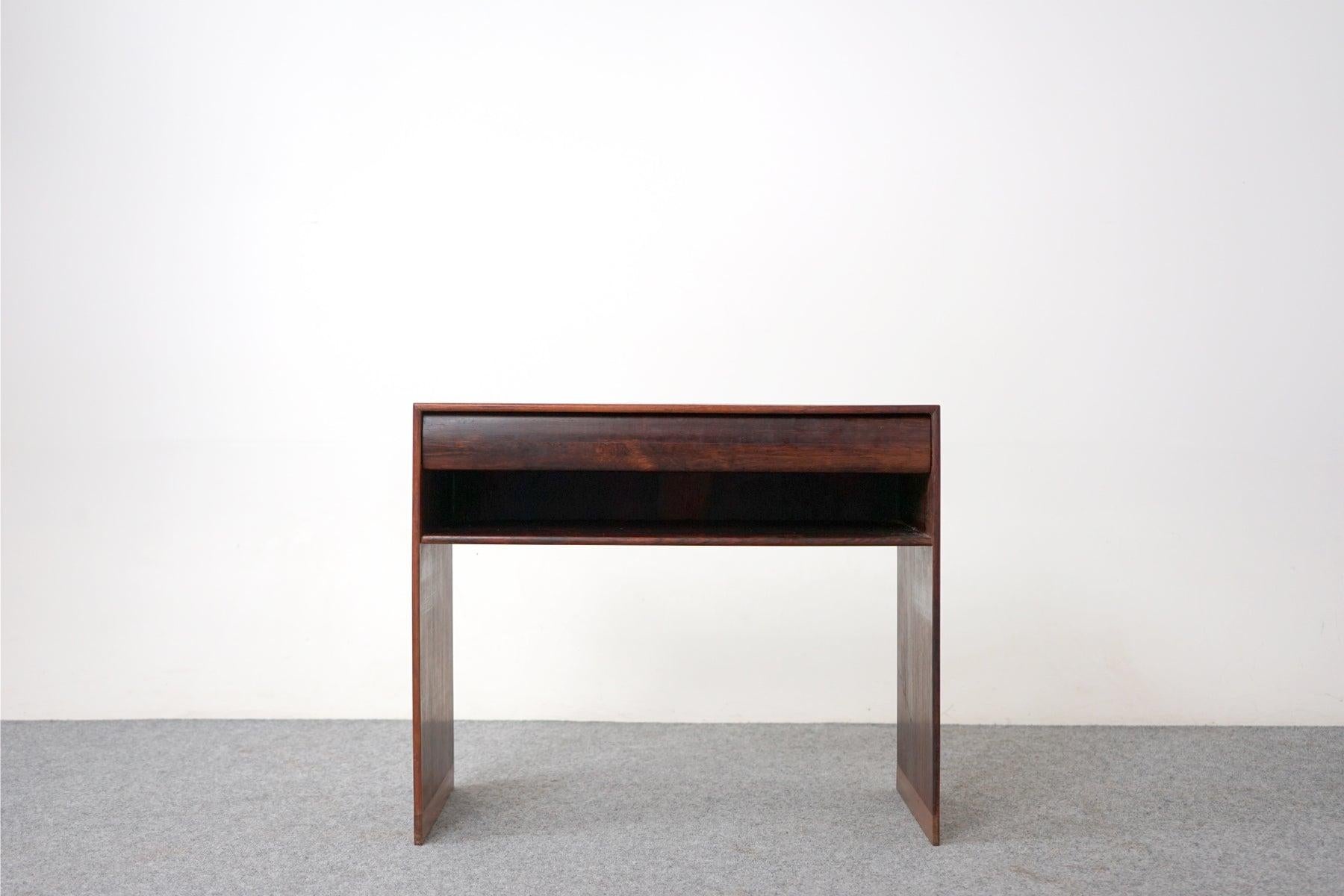 Rosewood side table circa 1960's. Compact yet highly functional table pairs perfectly with lounge chairs or anywhere extra surface is needed. Finished on both sides, it can work in every spot in the room, sleek drawer and convenient lower