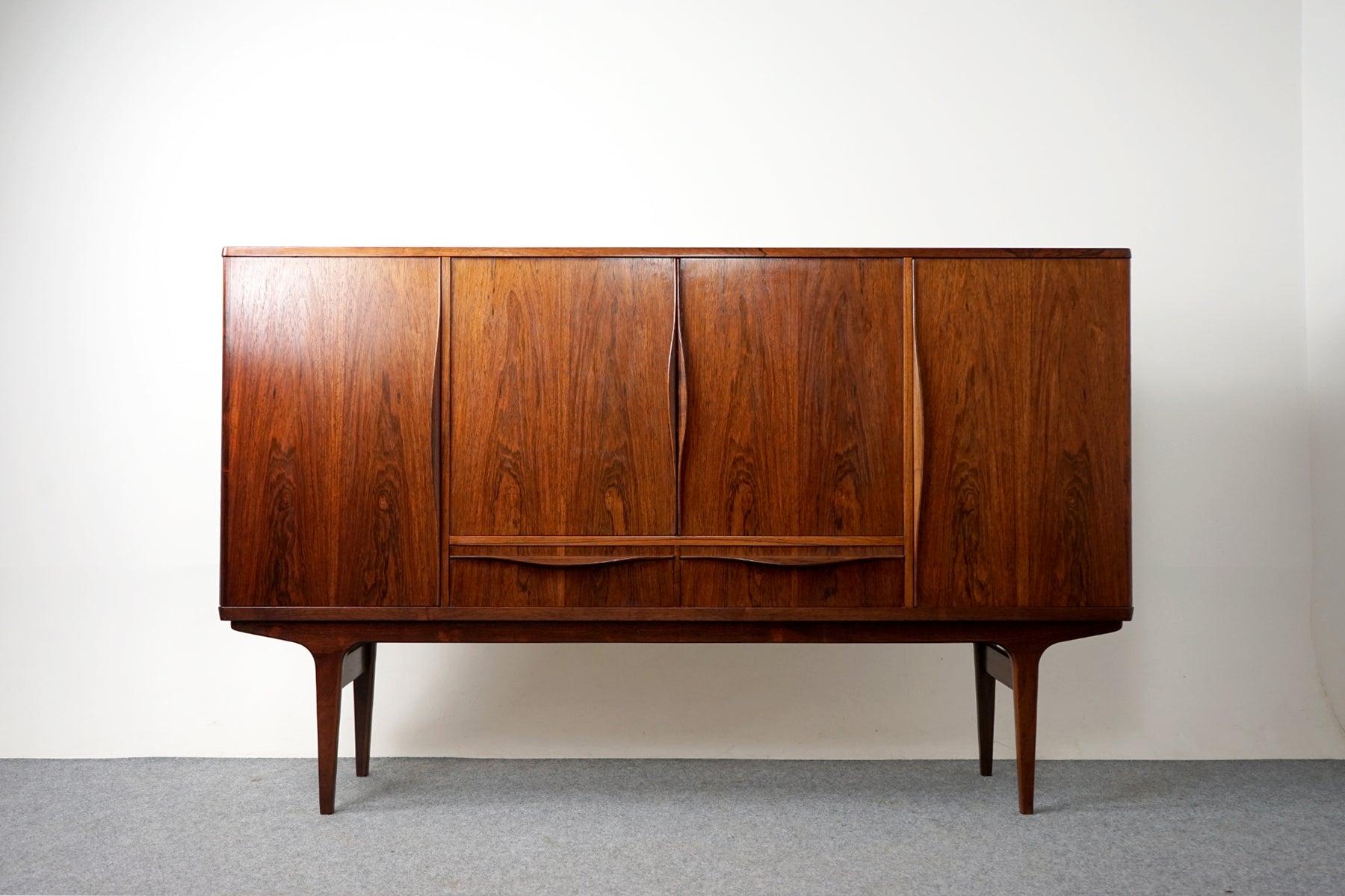 Rosewood Danish modern sideboard by LYBY Mobler, circa 1960's. A combination of sliding doors and exterior drawers offers ample storage for a variety of different uses. Clean, simple lined design highlights the exceptional book-matched veneer
