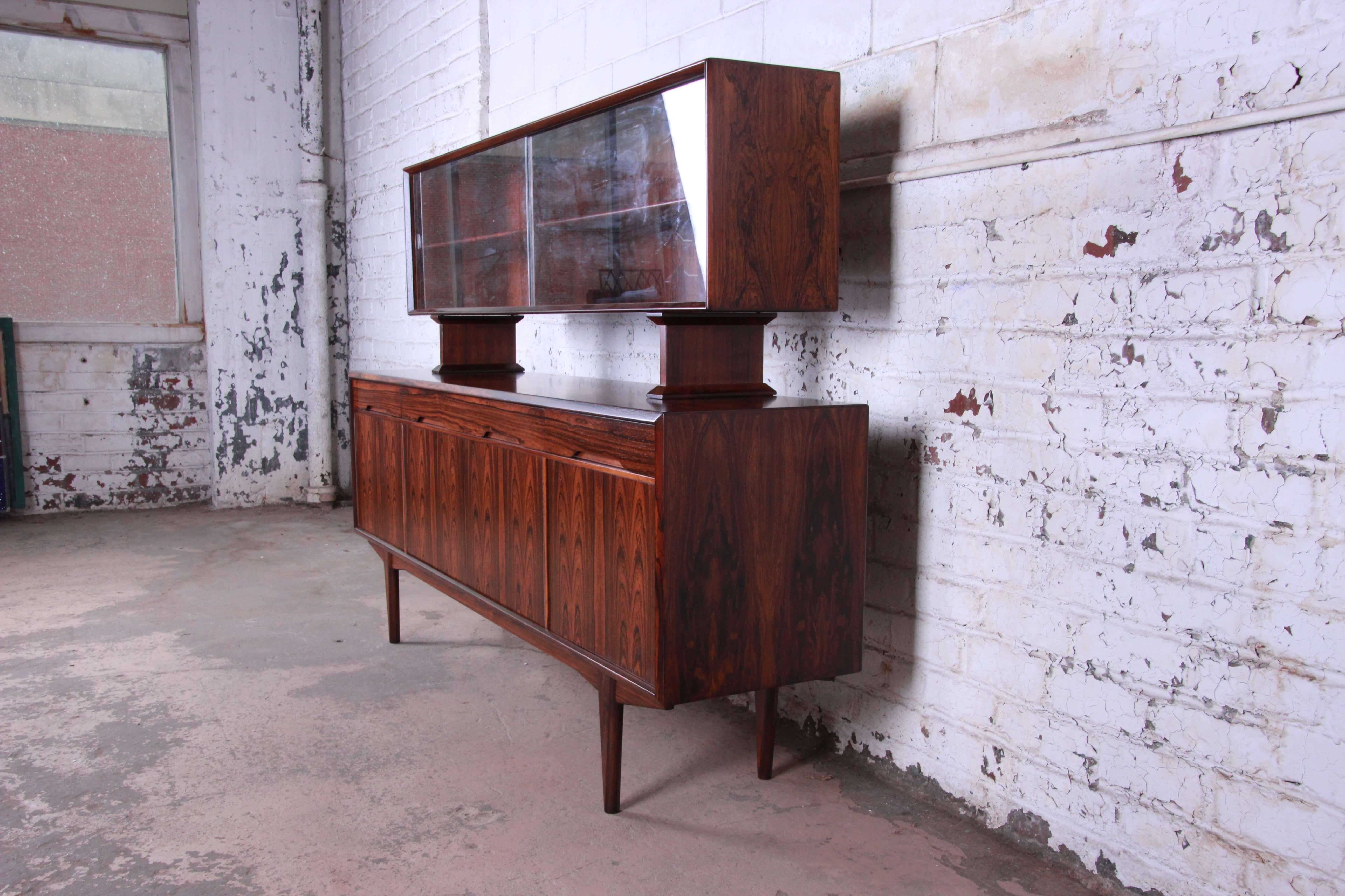 Offering an exceptional rosewood Danish modern sideboard credenza with a hutch-top. This Scandinavian piece has fantastic wood grain and is also finish on the back. There are two smaller drawers on each end of the top and a larger drawer in the