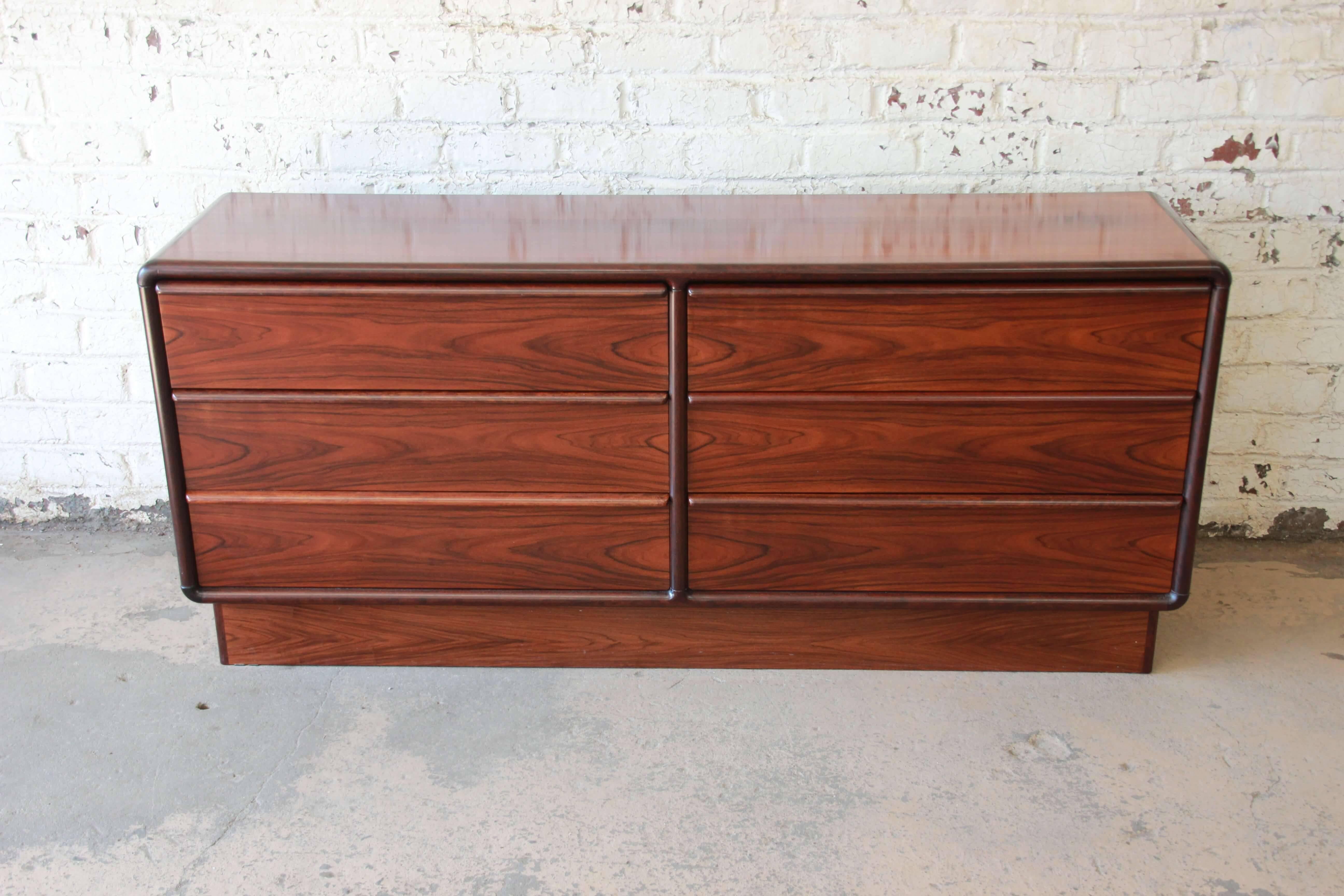 Offering a stunning Danish six-drawer rosewood dresser or credenza by Brouer. This piece has a beautiful wood grain that makes it a statement piece in any modern or Scandinavian environment. Each of the six drawers open and close smoothly while