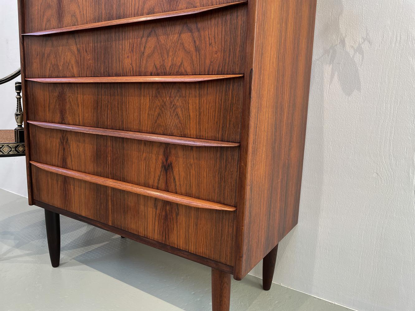 Danish Modern Rosewood/Palisander Tall Boy Dresser, 1960s.
Scandinavian Mid-Century Modern tall chest of drawers made in Denmark in the 1960s.
Classic six drawer dresser also known as a Tallboy on round tapered legs i solid rosewood. Full width