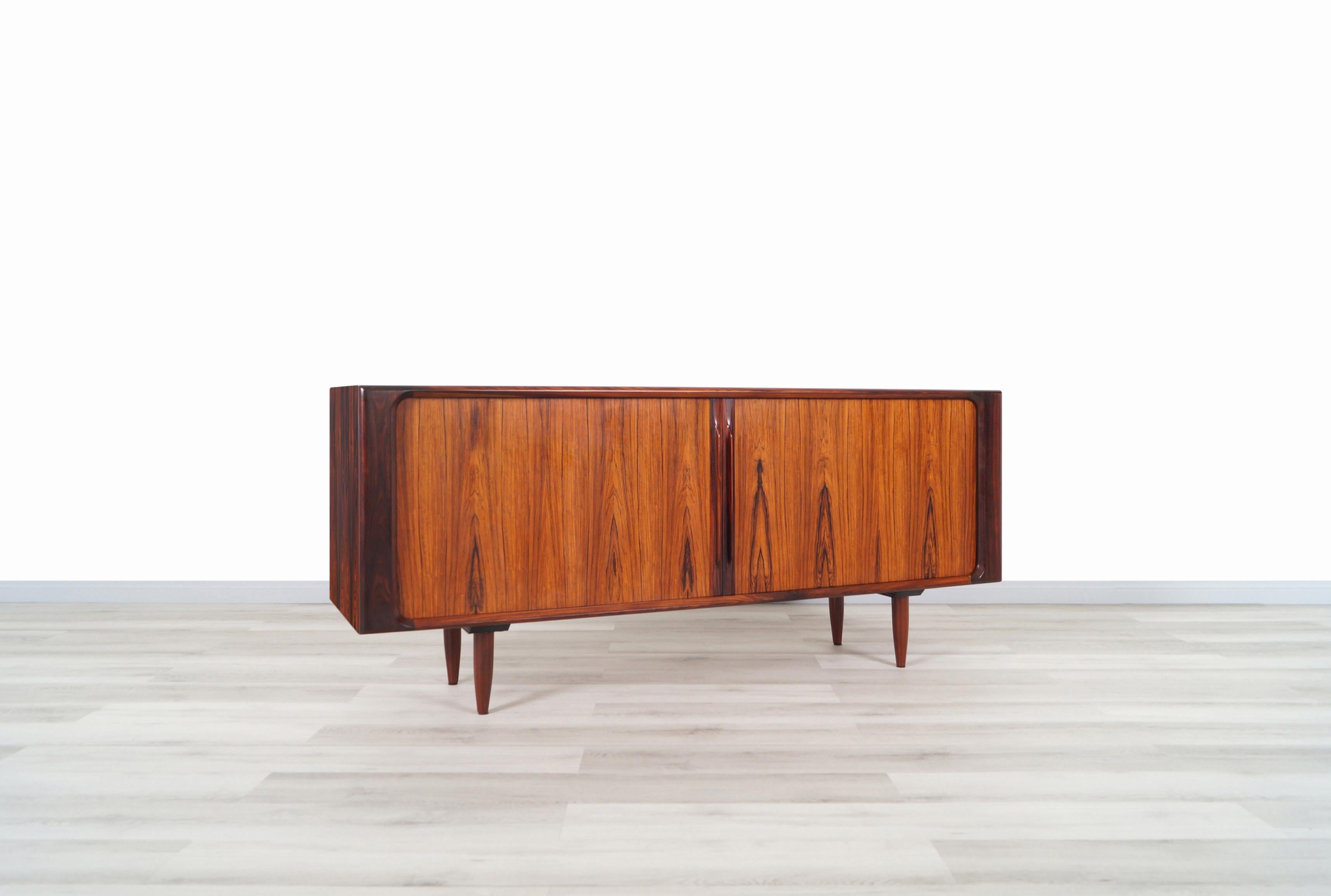 A stunning rosewood tambour doors credenza designed by Bernhard Pedersen & Son in Denmark, circa 1960s. This exceptional credenza features a well crafted Brazilian rosewood case with two tambour doors that smoothly glides open to reveal spacious