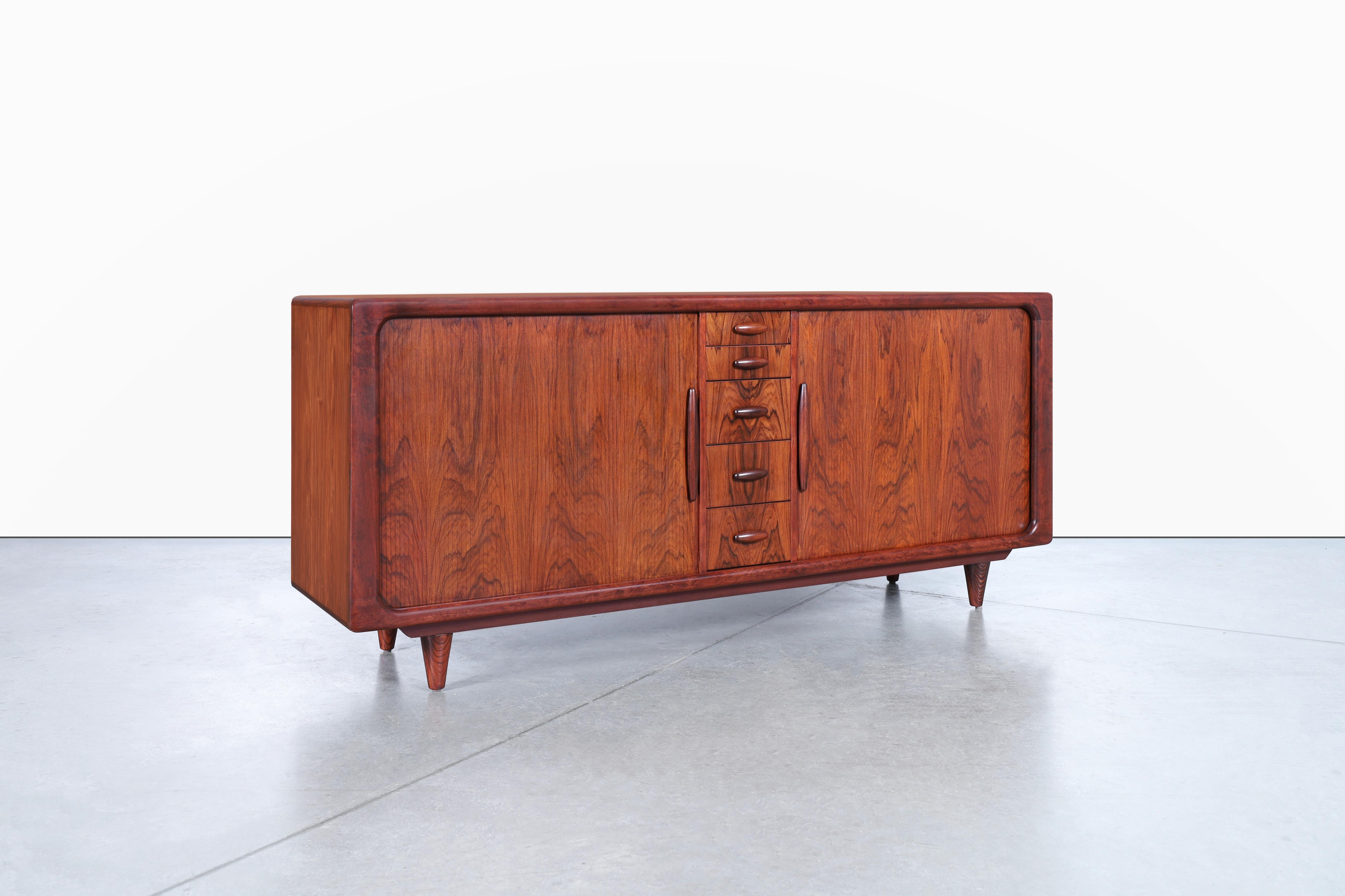 This stunning Danish modern tambour door credenza by Dyrlund, dating back to the 1960s in Denmark, is an elegant and practical piece of furniture that will add a touch of class to any room. The credenza has been expertly refinished, bringing out the