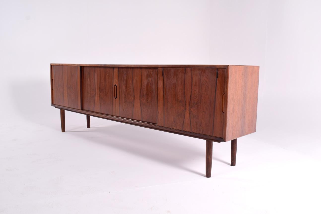 A very well made Danish TV cabinet/sideboard in rosewood, that dates from the 1960s-1970s with tambour sliding doors. Four doors offering plenty of storage. Each with an adjustable shelf. Lower than a normal sideboard. Perfect height for a TV