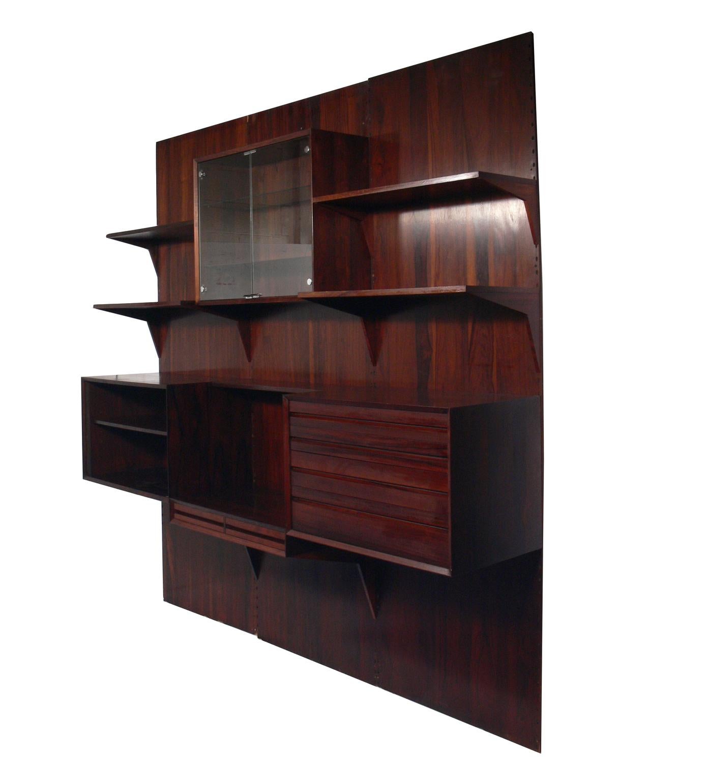 Danish modern rosewood wall unit, designed by Poul Cadovius for Cado, Denmark, circa 1960s. Beautiful graining to the rosewood. This piece is completely adjustable and any of the case pieces or shelves can be installed anywhere up and down the
