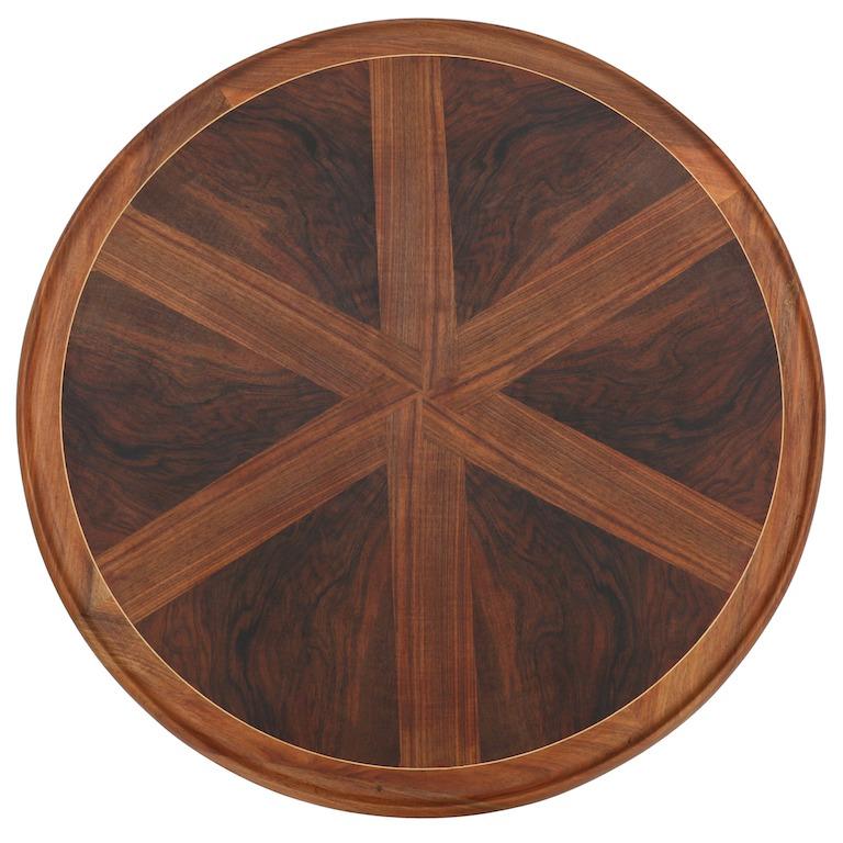 A Danish modern round coffee table of excellent design by a fine cabinetmaker, in walnut, the top being inlaid with walnut in a geometric pattern with a raised edge. The base, in ebonized wood is a standout, with curved stretchers, circa 1930s-1940s.