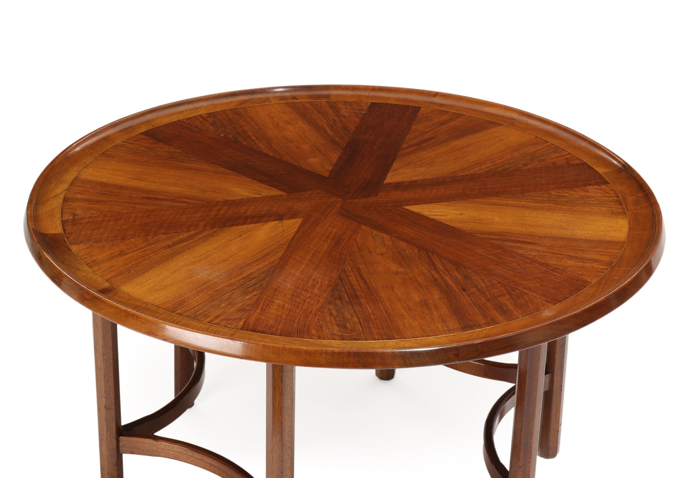 A Danish modern round coffee table of excellent design by a fine cabinetmaker, in walnut, the top being inlaid with walnut in a geometric pattern with a raised edge. The base, in ebonized wood is a standout, with curved stretchers, circa 1930s-1940s
