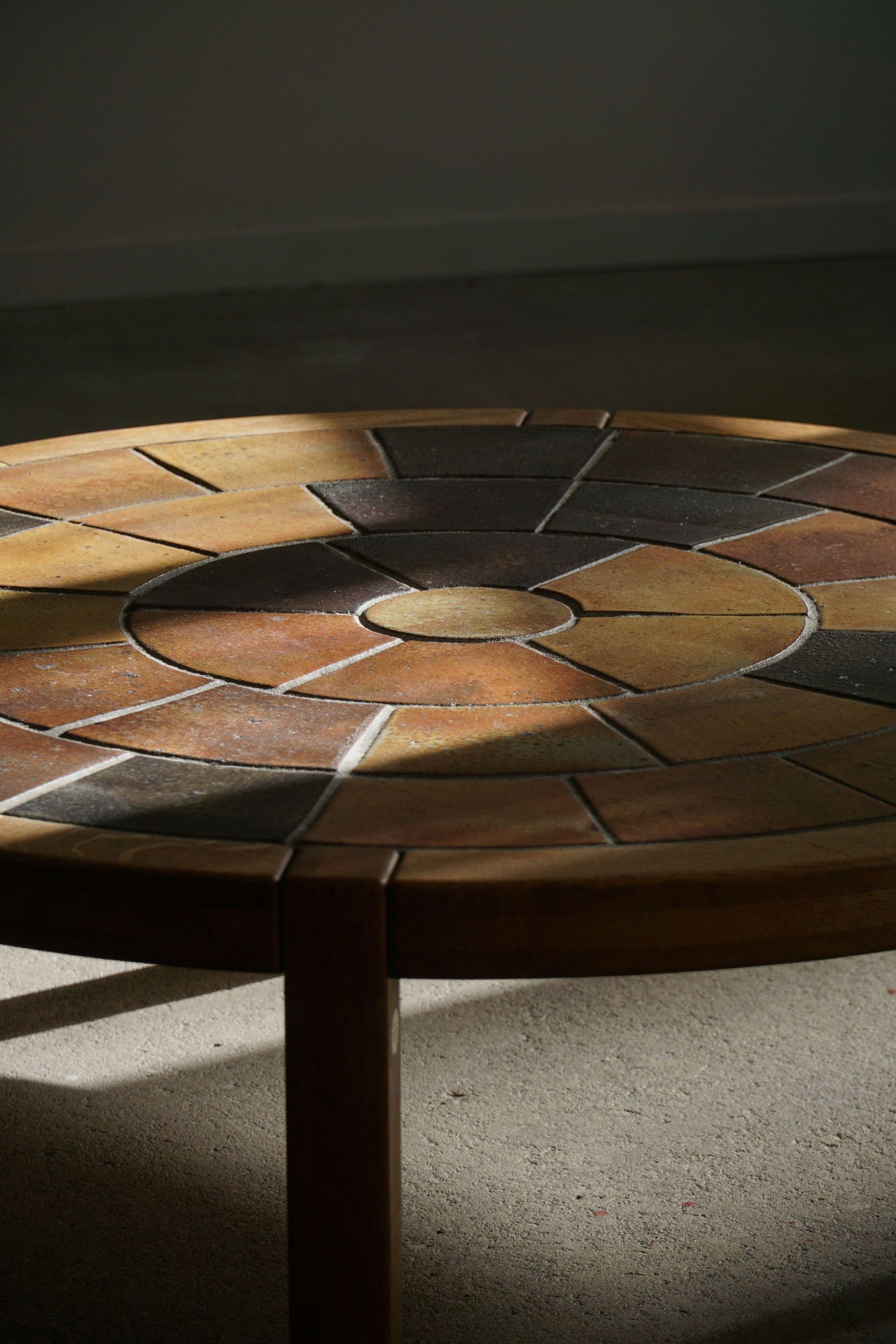 A magnificent Danish Modern round shaped coffee in teak, top made with handmade ceramic tiles. Designed by Britt Sallingboe in 1981, Denmark. Signed here by. 

This lovely table will complement many interior styles. A modern, antique, classic,