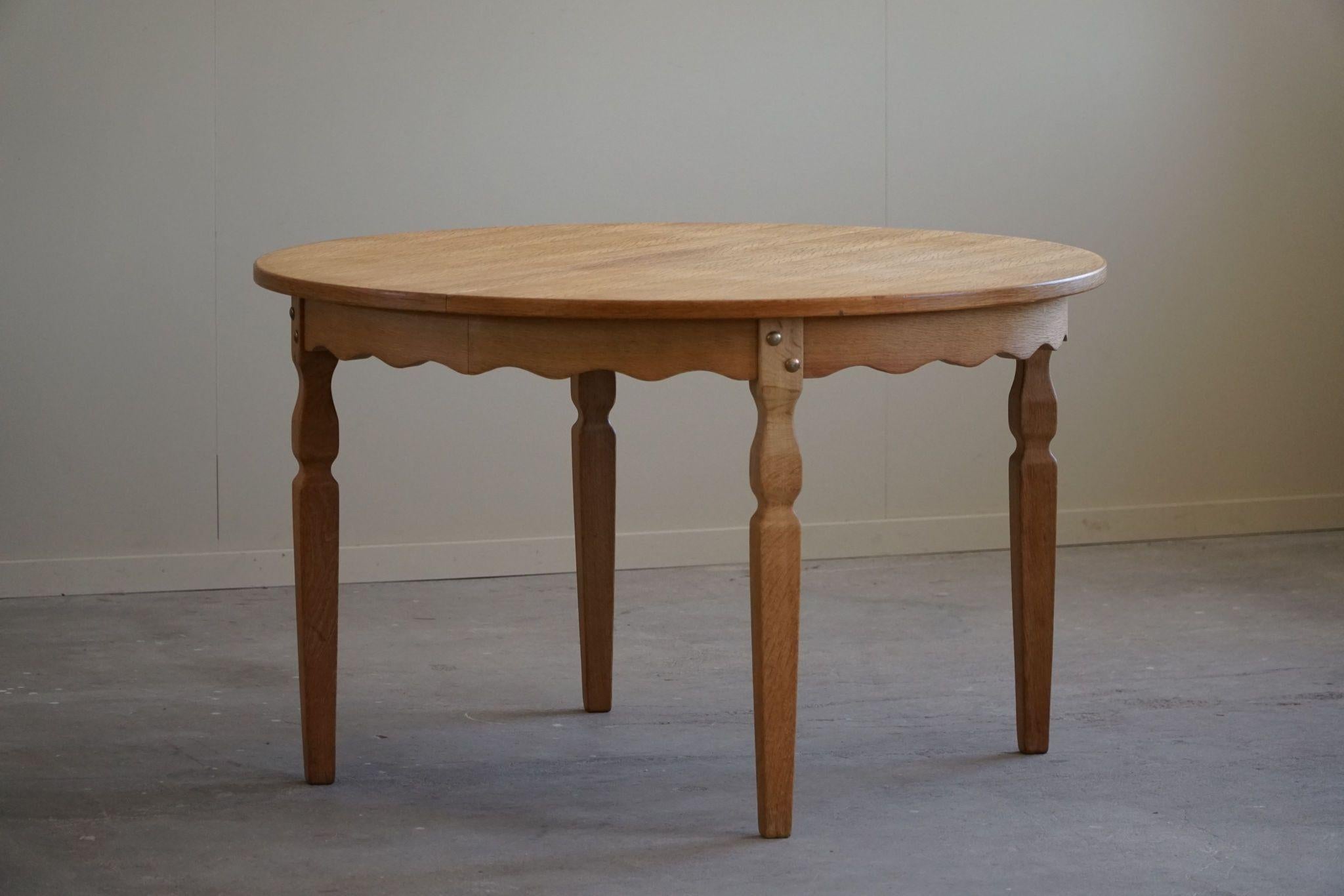 Classic round dining table in oak with two extensions, made in the 1960s by a Danish Cabinetmaker. Such a sculptural figure for the modern interior.

Curved legs and great craftmanship in this brutalist table. 
Light signs of wear on the
