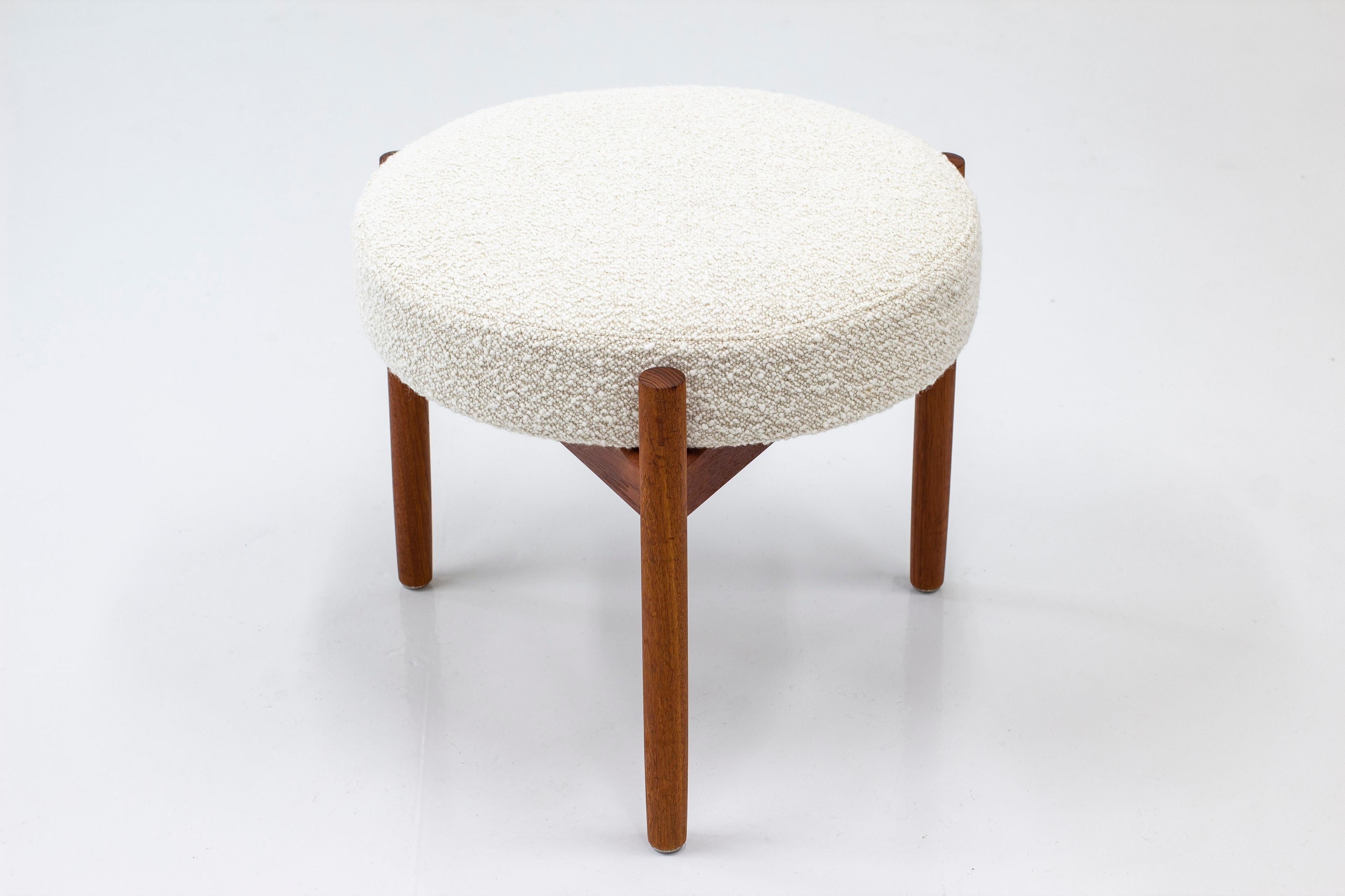 Round stool designed by Hugo Frandsen. Produced by his own company in Denmark during the 1960s. Made from solid teak with off-white melange wool upholstery in a bouclé style. Very good vintage condition with light signs of age related wear and