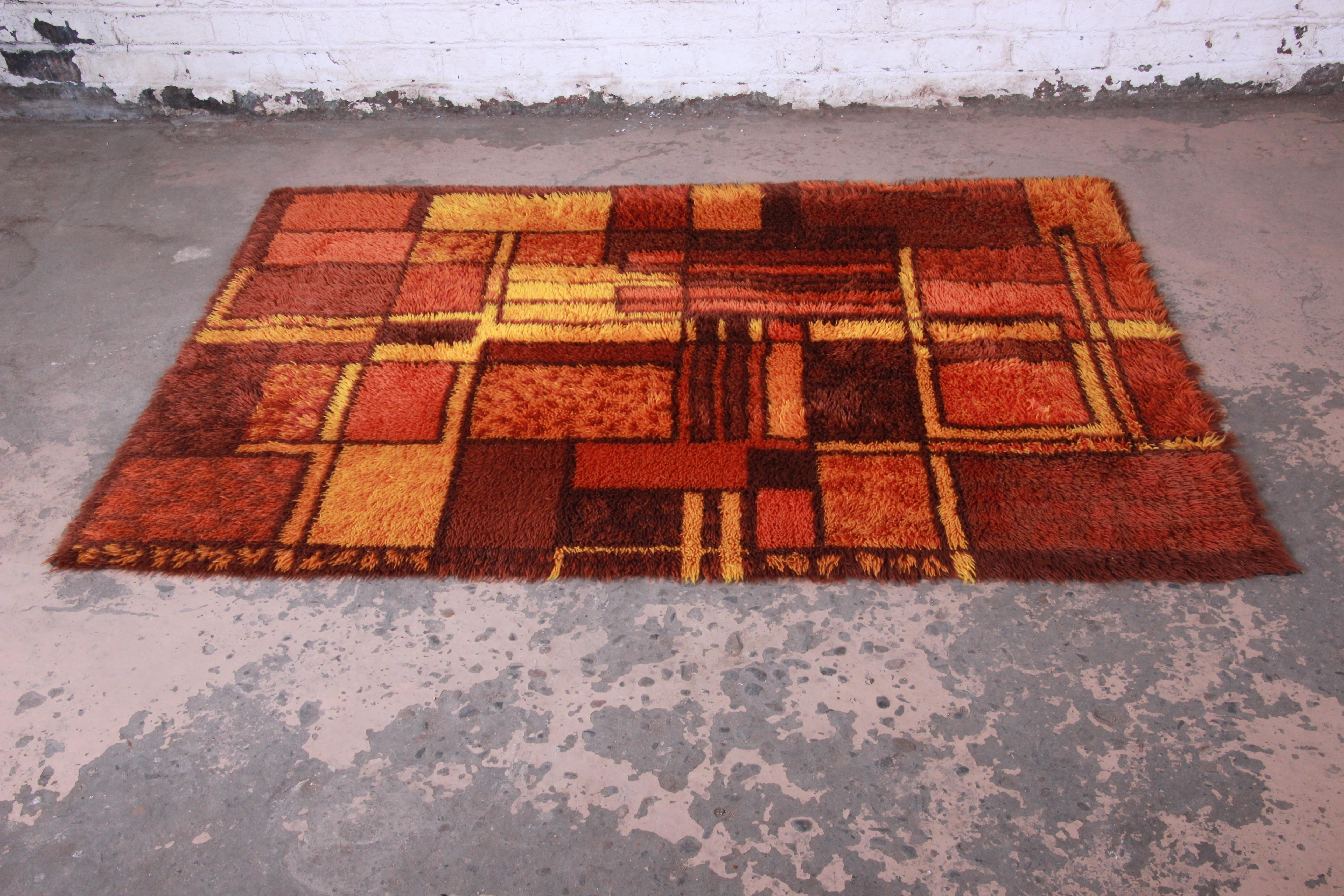 A gorgeous midcentury Danish modern Rya Shag rug. The rug has a unique abstract geometric design, with vivid colors in red, orange, and yellow. It has a thick wool pile and is in very good vintage condition. Measure: 4'5