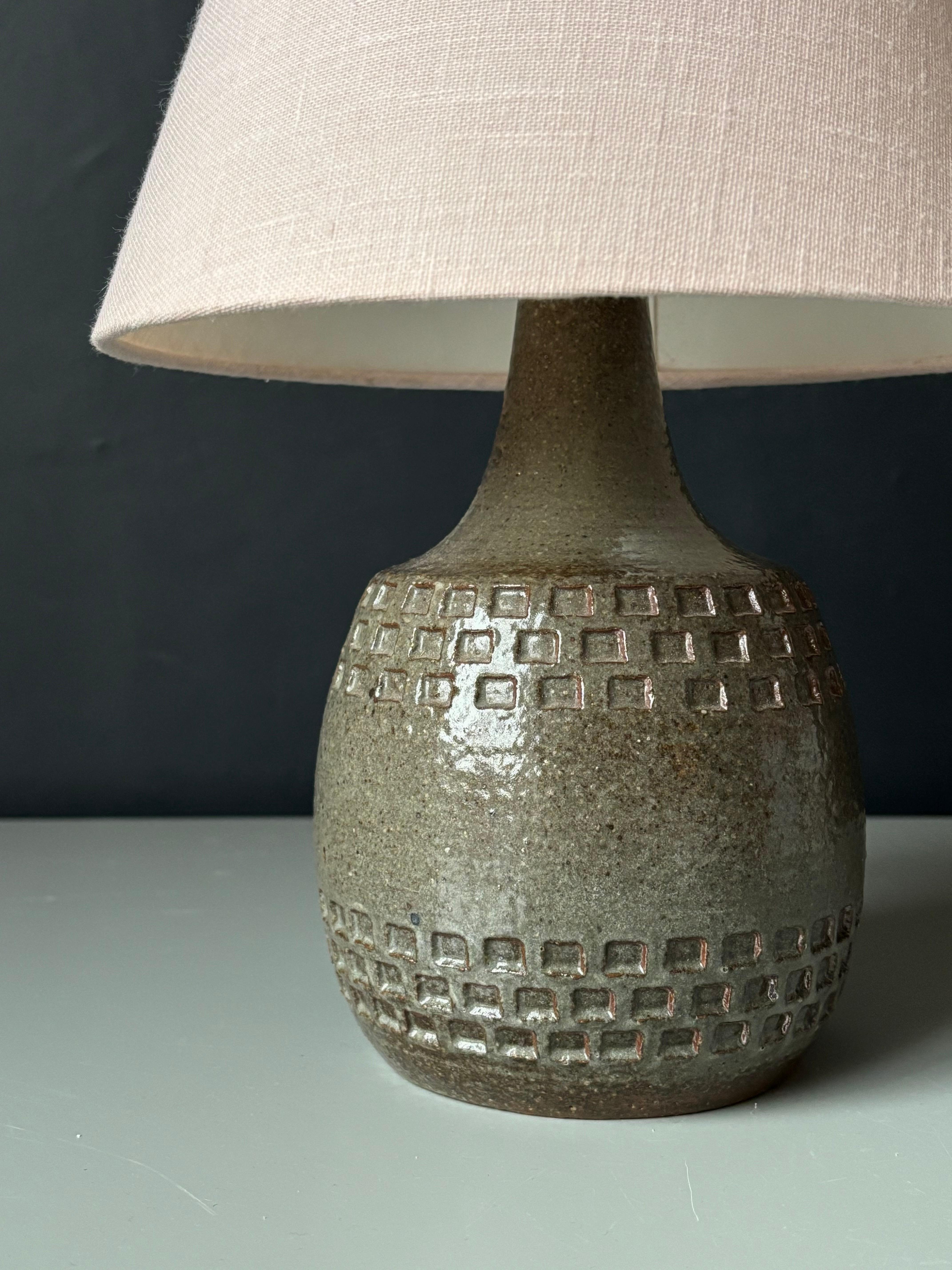 Lampe de table en grès moderniste danois du milieu du siècle des années 1960 par Søholm Stentøj. Superbe glaçure brillante vert sauge poussiéreux avec des tons bruns terreux sur un corps aux formes douces avec des impressions de décor carrées et un