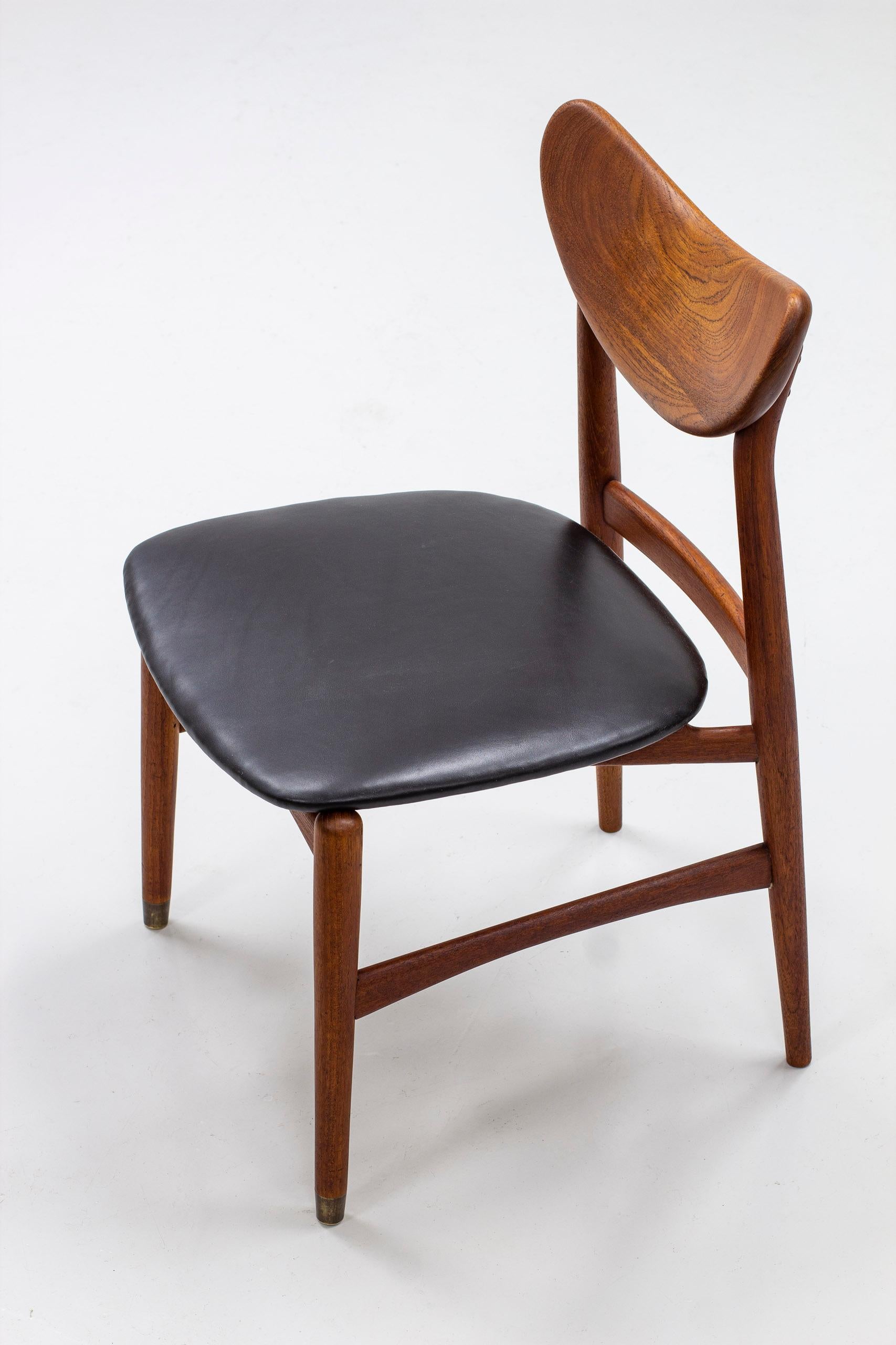 Side chair designed and made by cabinetmaker Oluf Jensen. Made in Denmark during the 1950s. Made from solid teak with a sculptural teak backrest. Seat reupholstered in black leather. Front legs finished off with brass feet. Good vintage condition