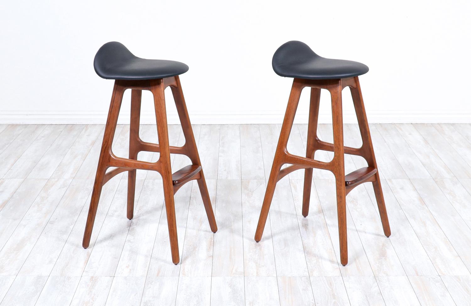 Pair of modern bar stools model 61 designed by Erik Buch for Oddense Maskinsnedkeri and manufactured in Denmark circa 1950s. These exceptionally crafted stools feature a minimalist streamline with a solid teak wood frame and a gorgeously contrasting