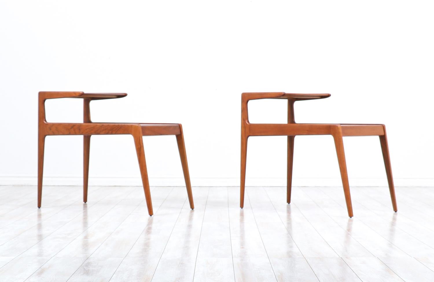 Pair of Danish Modern side tables designed by Kurt Østervig and manufactured by Jason Møbler in Denmark circa 1950’s. This set of tables with two tiers and sharp, clean lines are a great example of well-crafted minimalistic design. Their versatility