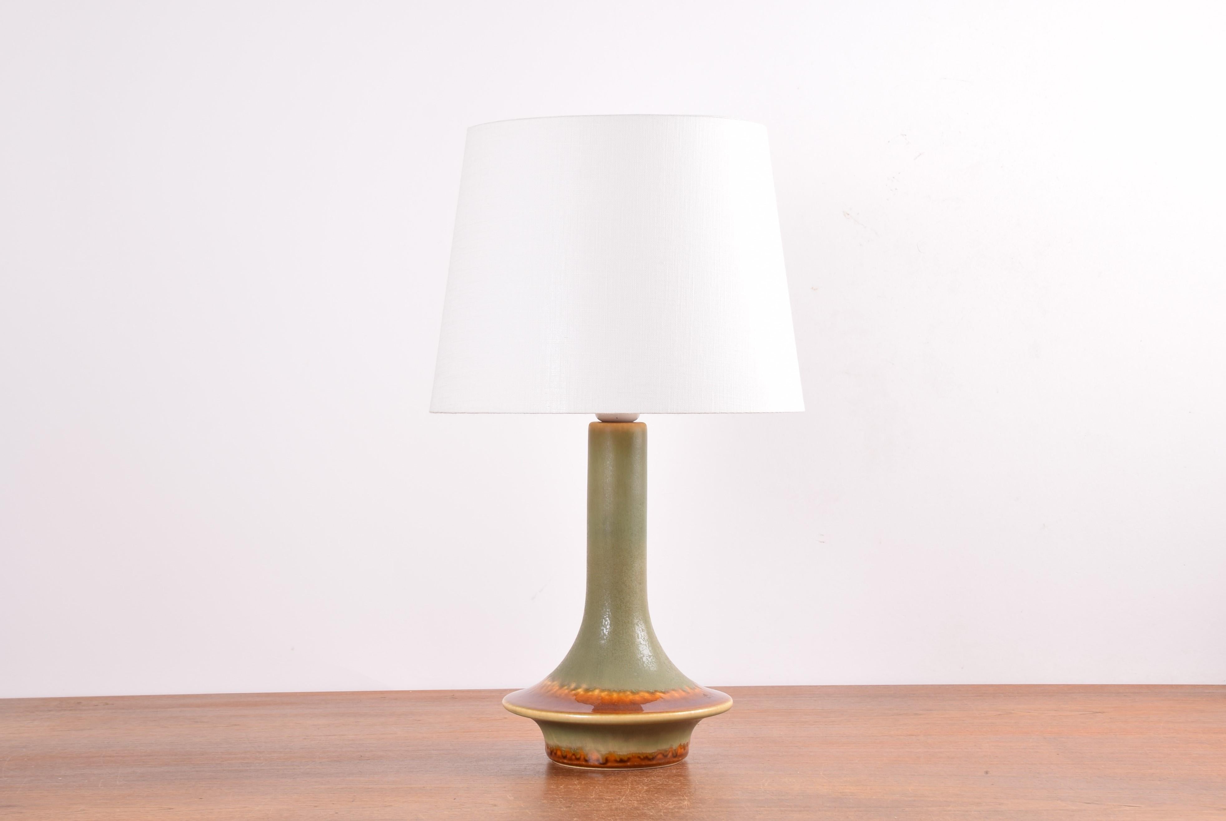 Midcentury Danish sculptural table lamp from Søholm Stentøj, Denmark, circa 1960s.
The lamp is decorated with a matte green glaze contrasted by a shiny running caramel brown glaze. 

Included is a new lamp shade designed and made in Denmark. It