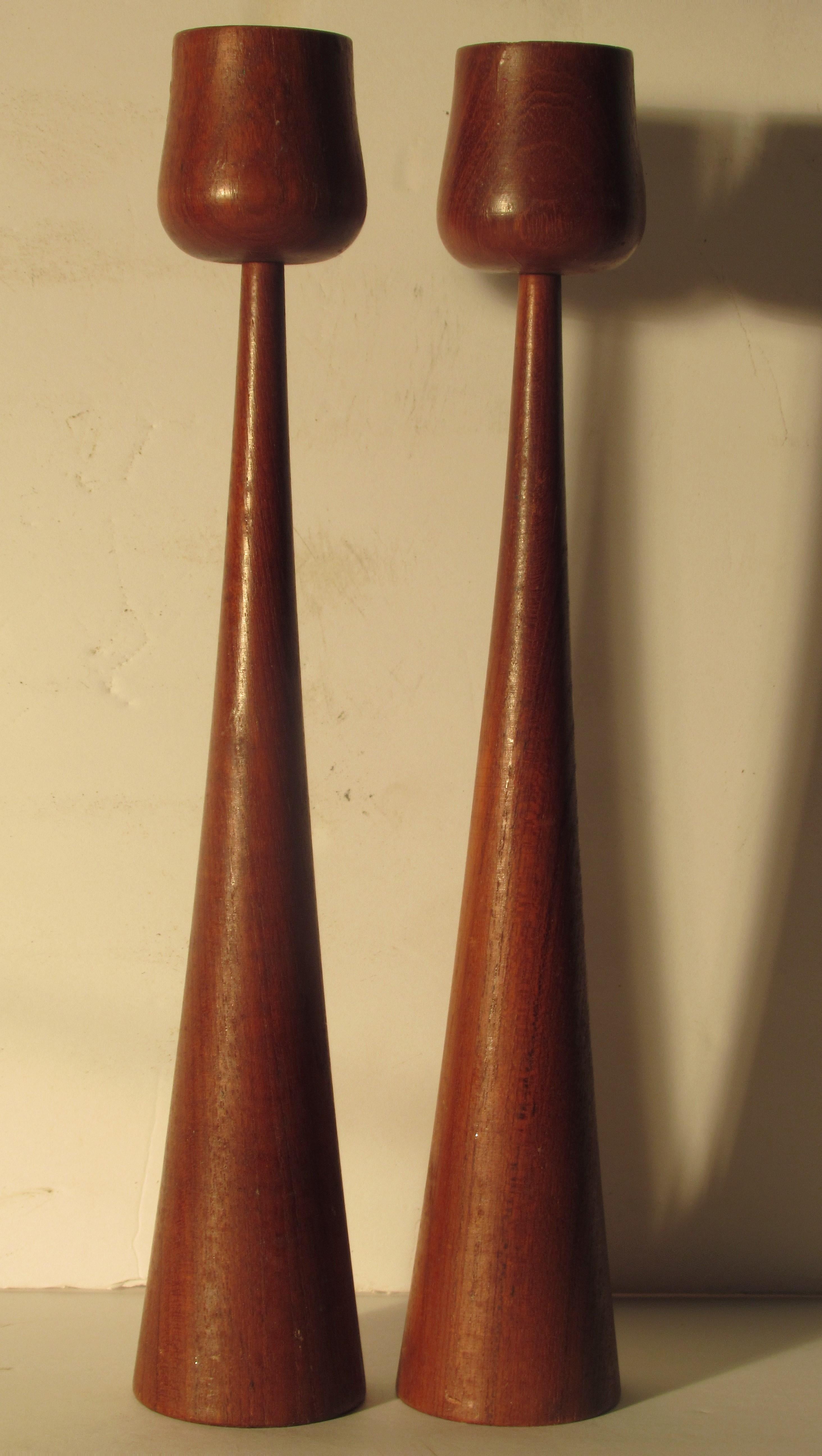 A great looking pair of tall sculptural candlesticks with beautifully aged original deep rich color patina to turned teak wood. Old foil label on underside of one candlestick reads Made in Denmark, circa 1960.