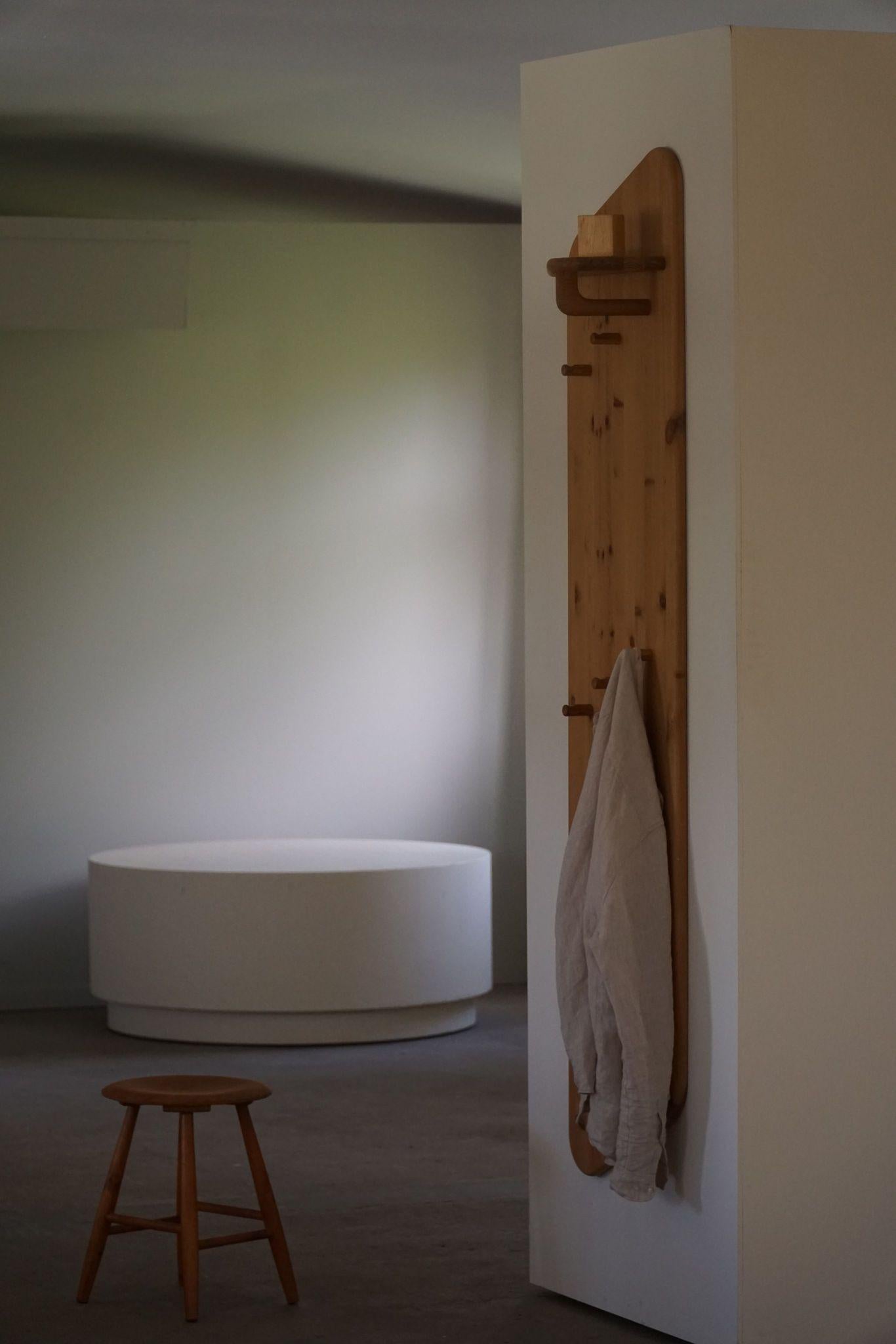 Questo grande appendiabiti da parete, realizzato da un ebanista danese negli anni '80, è realizzato in pino massiccio con un design moderno danese. Lo scaffale presenta un'estetica pulita e minimalista, con linee semplici e venature naturali del