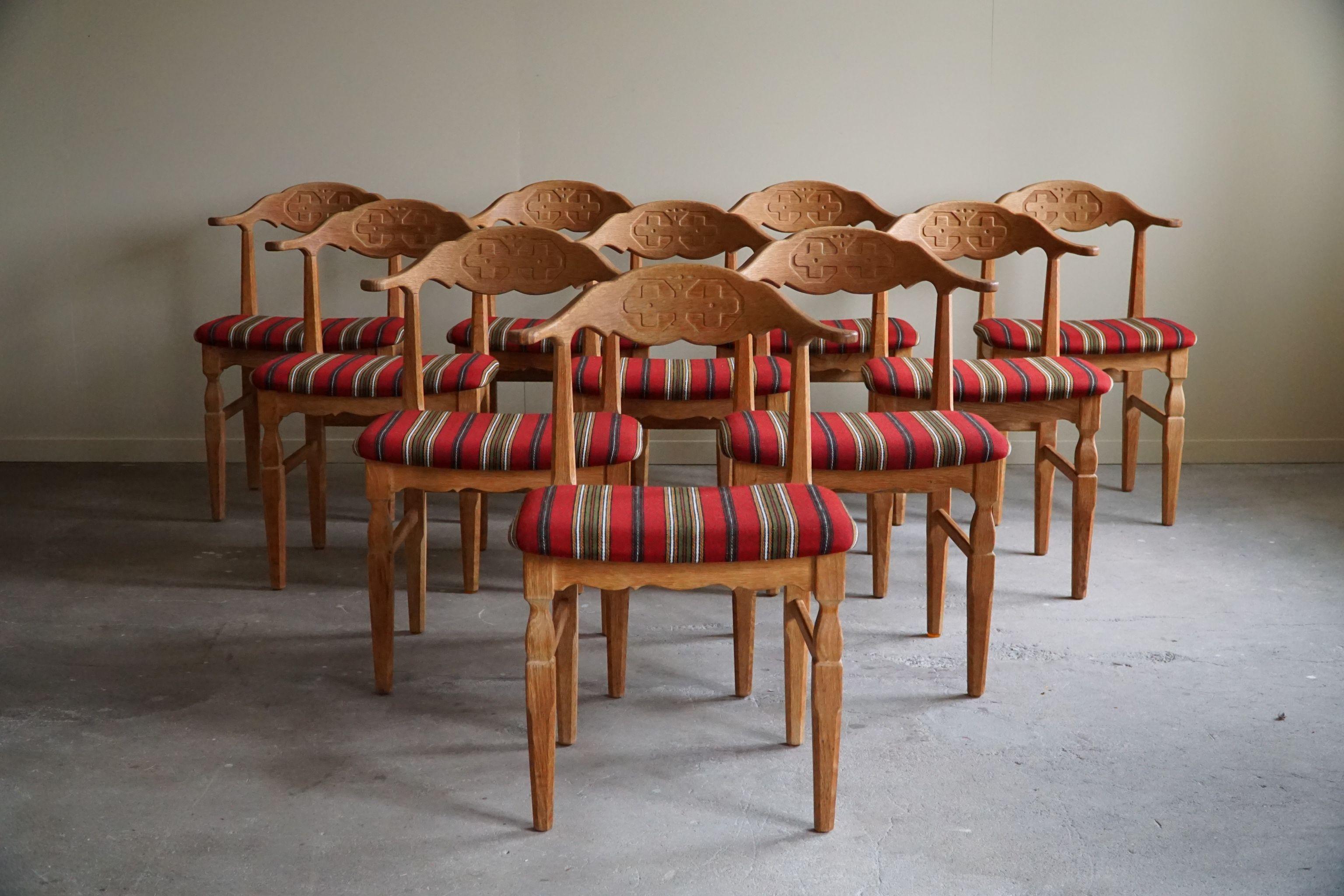 A sculptural classic set of 10 dining chairs in solid patinated oak with seats in its original wool fabric. Made by Henning (Henry) Kjærnulf for E.G. Møbler - circa 1960s.

These modern chairs have a really strong impression that pairs well with