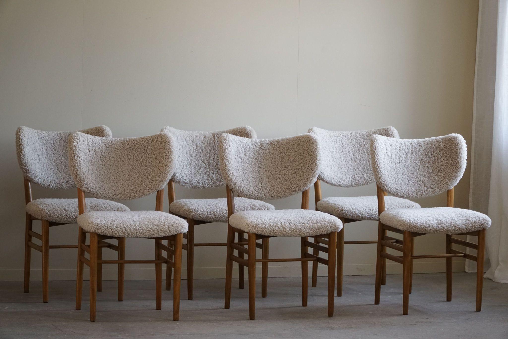 An extraordinary set of 6 dining chairs in beech & teak, seats and back reupholstered in a high quality shearling lambswool. Designed by Nils & Eva Koppel in ca 1955 for Slagelse Møbelfabrik. The chairs feature the classic butterfly backrest.