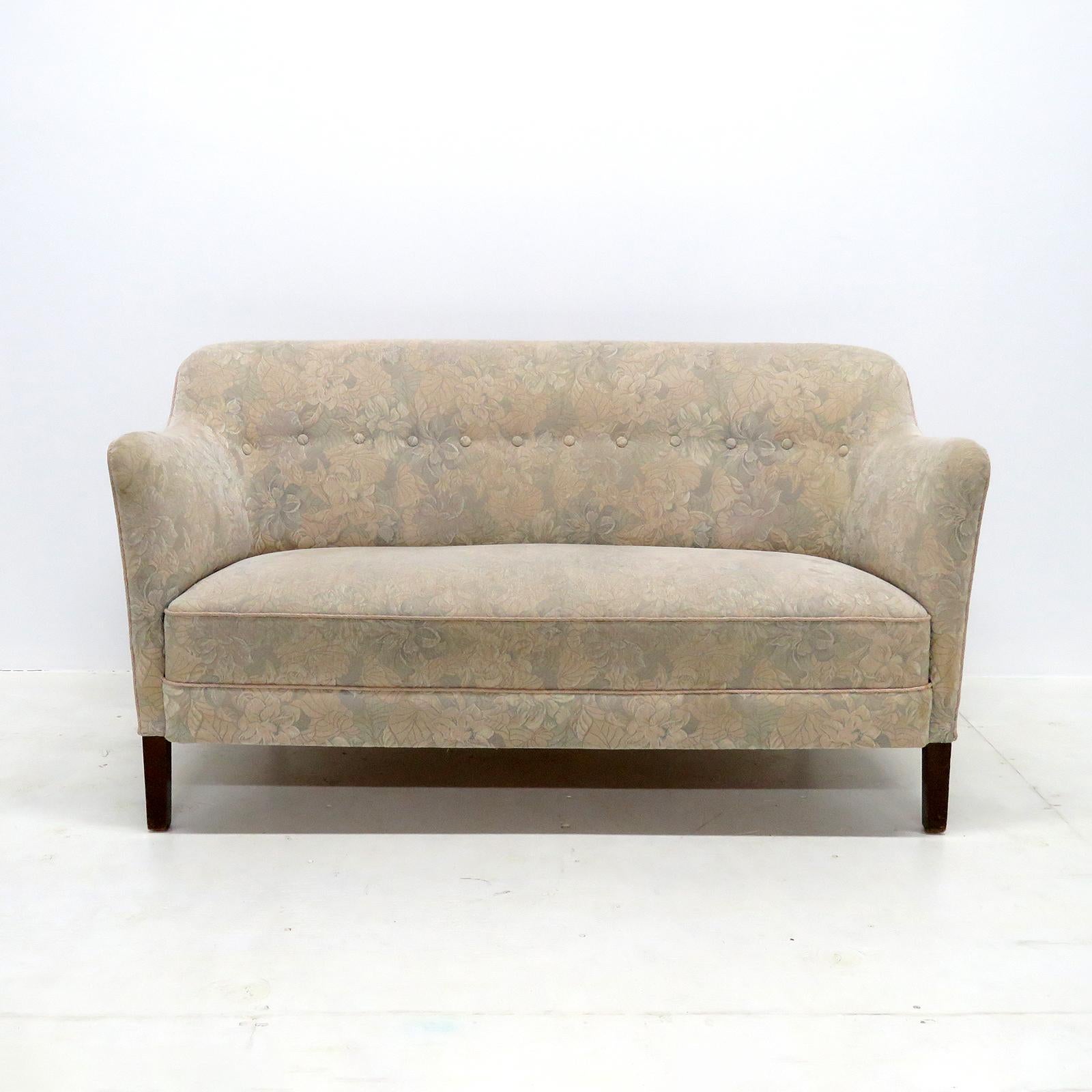 Wonderful Danish modern settee from the 1940s, dark stained beech legs with a multicolored, floral themed upholstered and tufted body.
