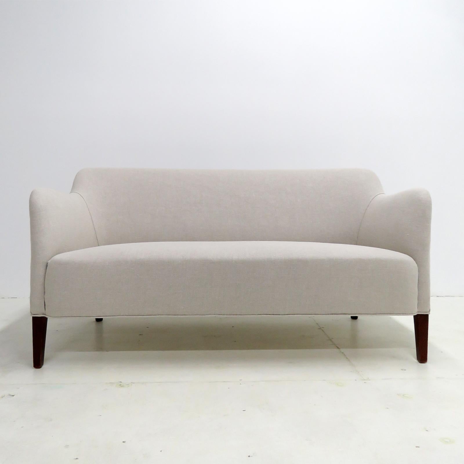 Wonderful Danish modern settee designed by Jacob Kjaer, 1940s, dark stained beech legs with a newly upholstered linen fabric.
