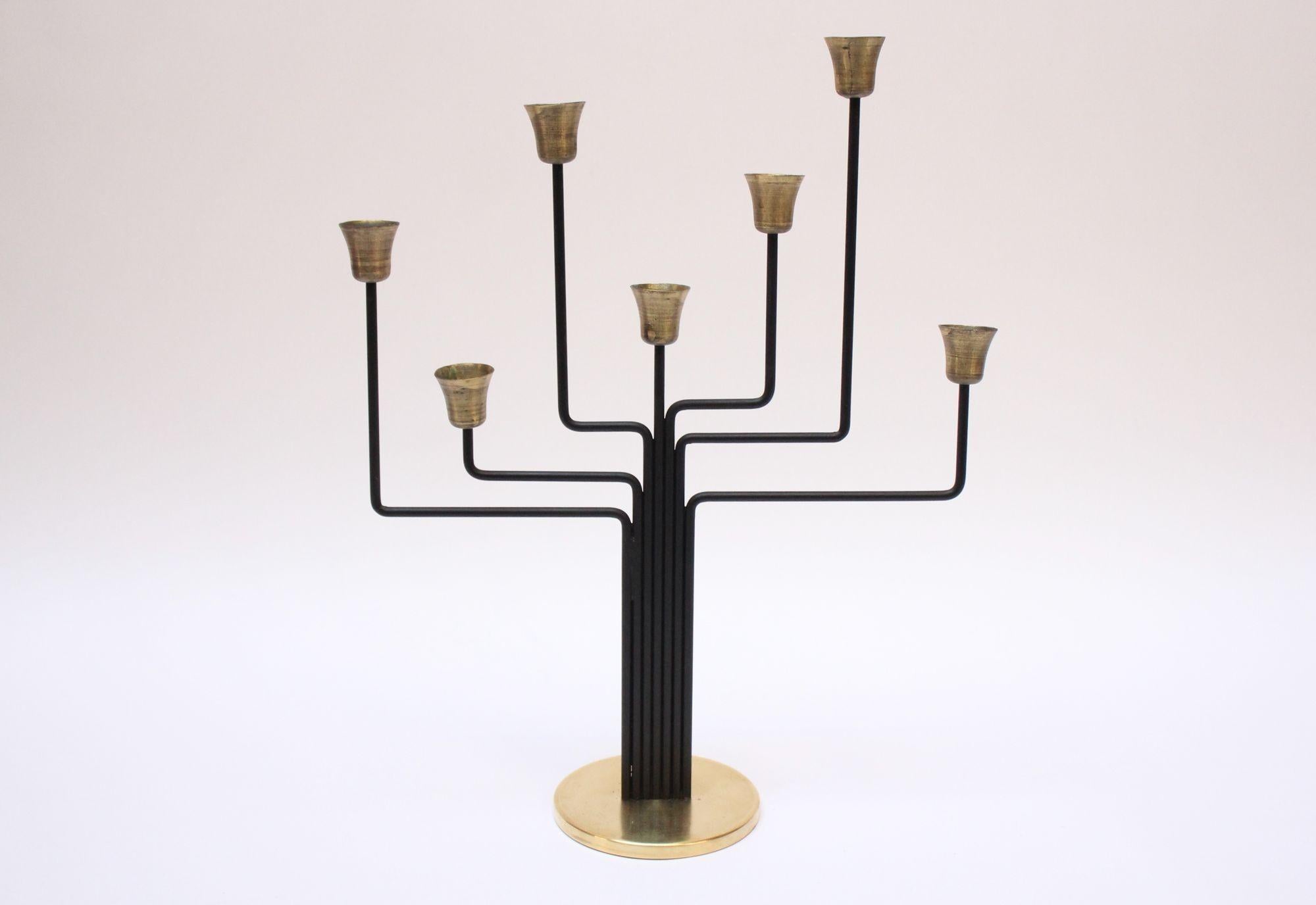 Sculptural seven-arm candelabrum designed by Svend Aage Holm Sørensen (ca. 1960s, Denmark). Composed of black lacquered metal 'branches' and brass circular base and candle cups. Tarnish to the unpolished candle holders and a few spots of tarnish to