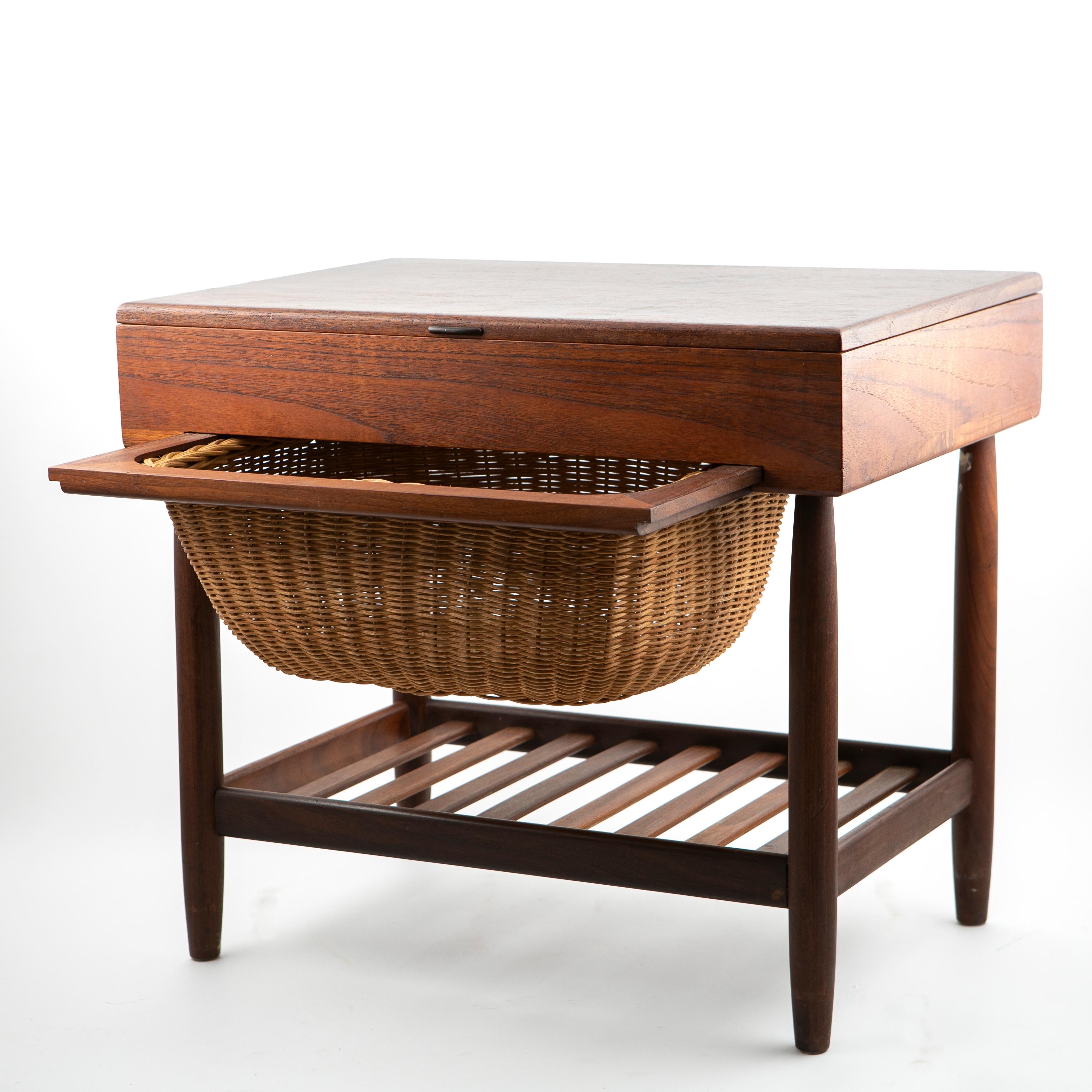 Danish design sewing table / end table
Designed by Ejvind Johansson made in Denmark by FDB Mobler.
Teak vener and maple compartments under a removable wicker basket.

Would also serve well as an end table or night stand.