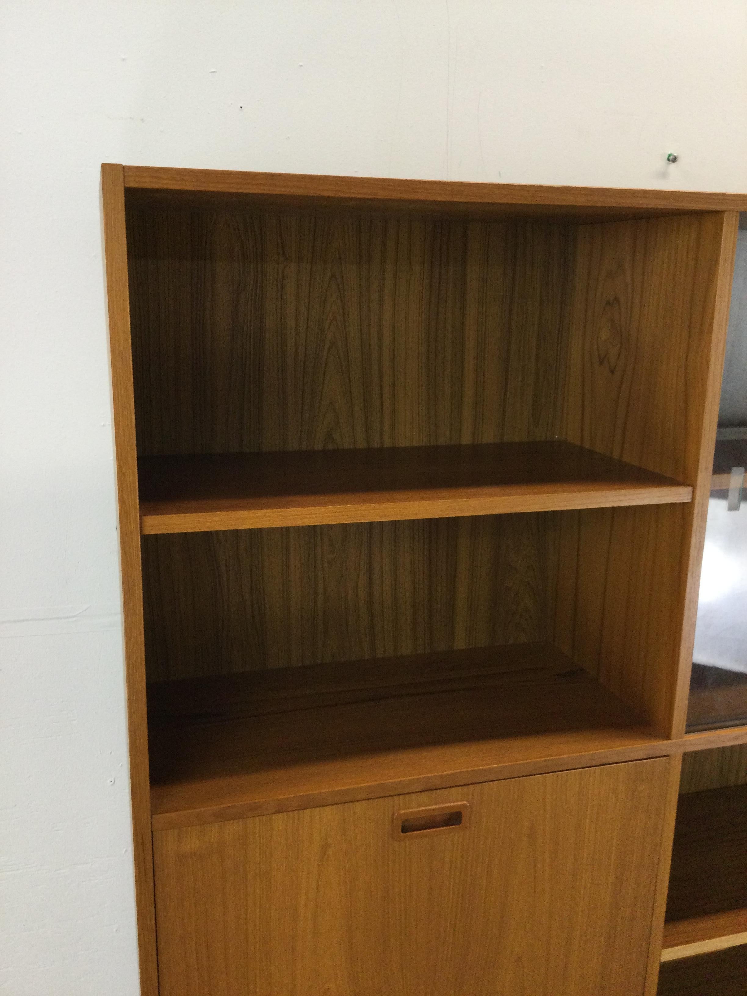 Glass Danish modern shelving unit with sliding glass doors and drop front cabinet