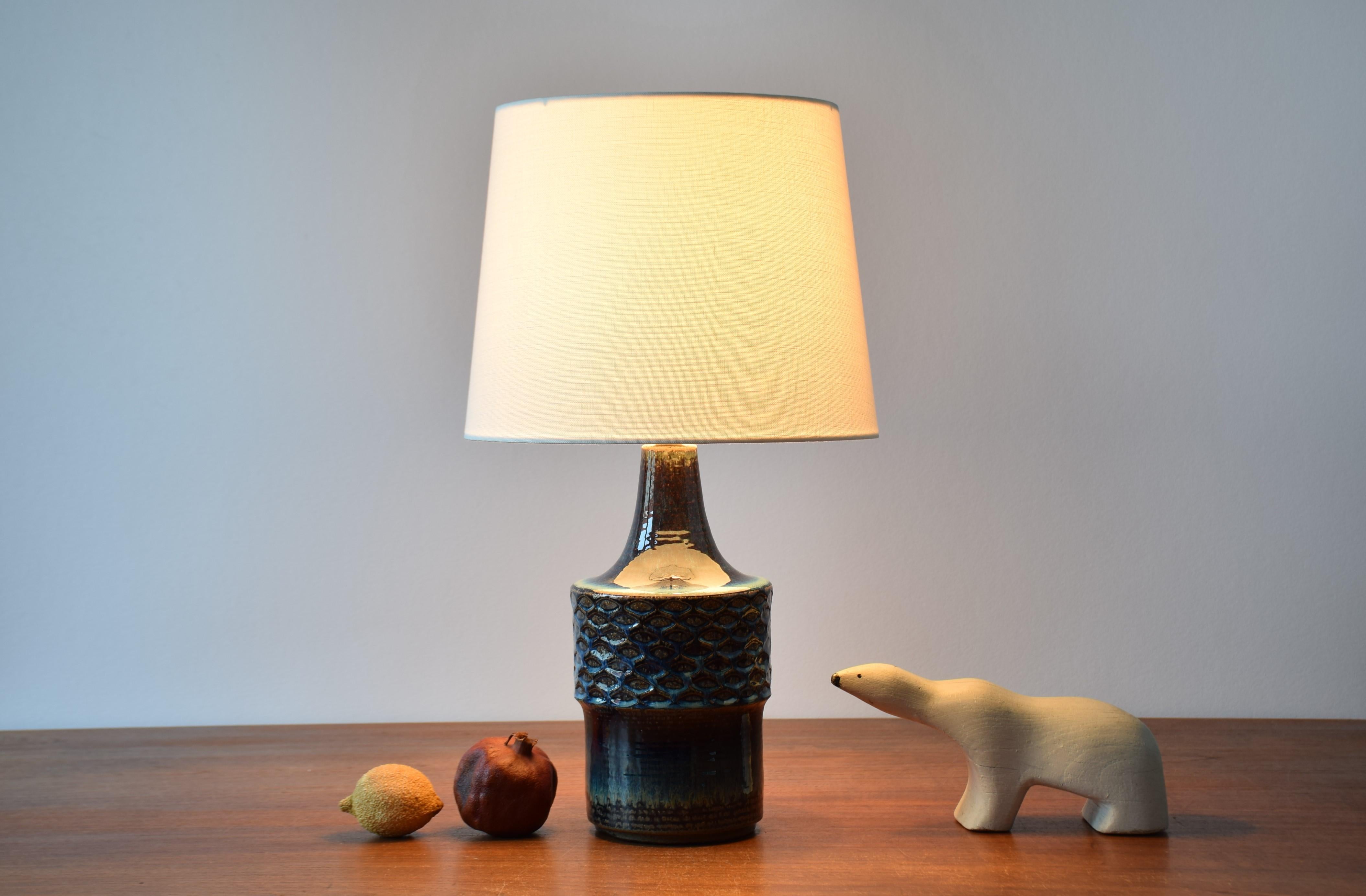 Rare Mid-century Danish table lamp from the acknowledged stoneware manufacturer Søholm. Made circa 1960s.

The lamp has a shiny glaze in deep blue, brown and beige colors. The body of the lamp shows a repeated pattern which seems to be inspired by