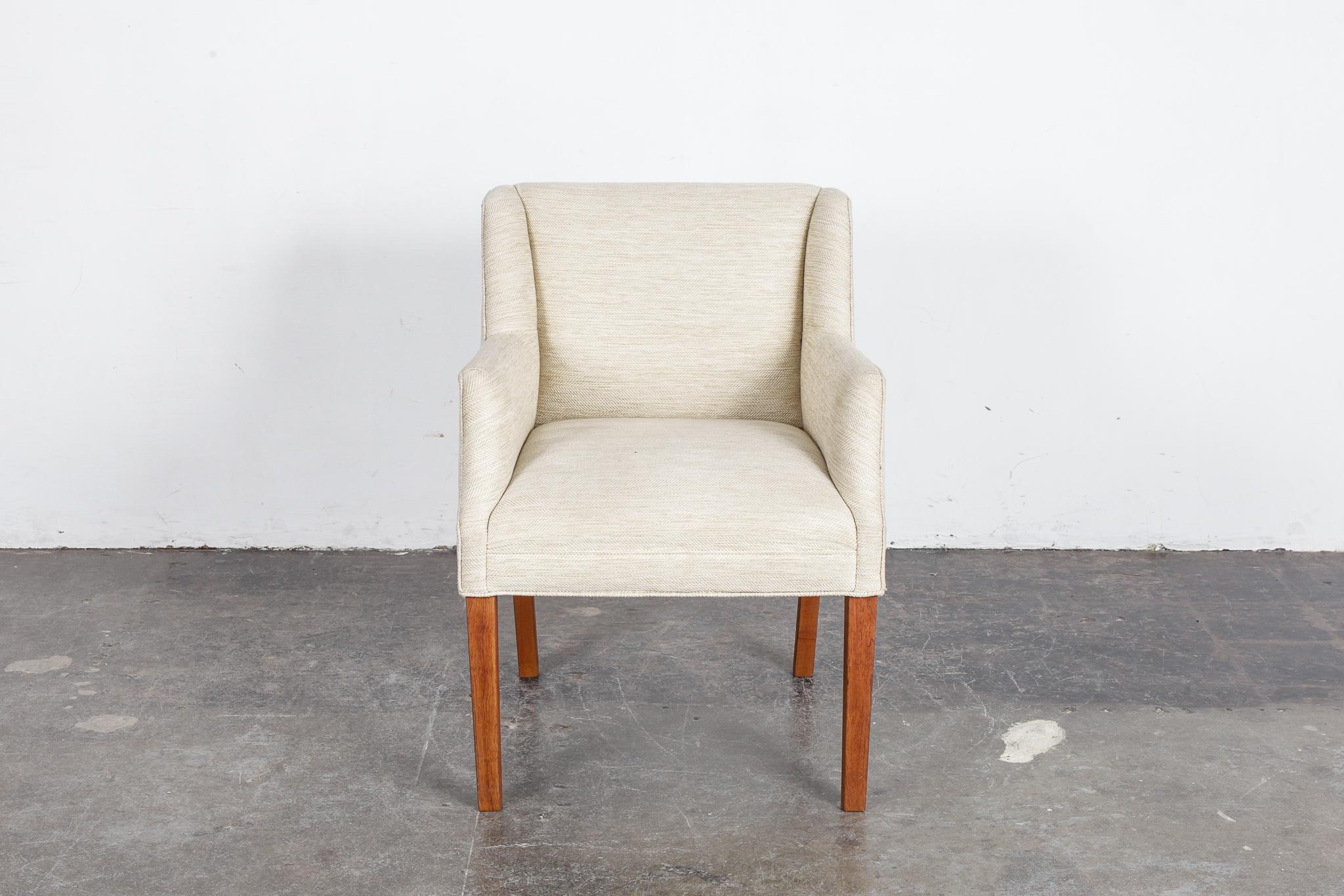 Danish Mid-Century Modern side chair featuring elegantly curved arms and a slightly taller seat height. Newly upholstered in an off white, with hints of yellow, woven fabric. Legs have been refinished in a natural oil finish. Nice lines especially