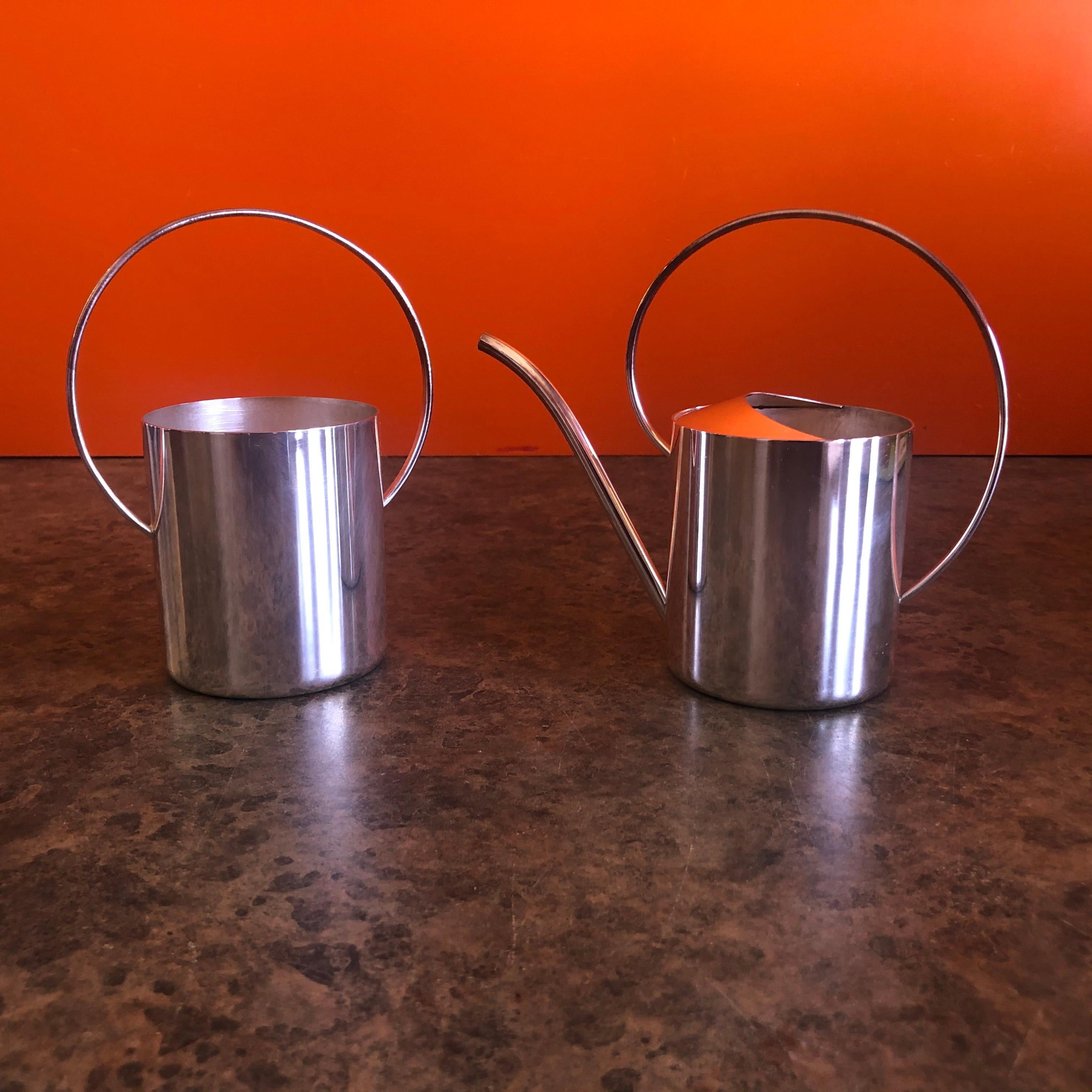 Striking Danish modern silver plate cream and sugar set by Eleanor Claire, circa 1960s. The highly crafted two-piece set is in the form of a watering can and garden pail. Very cool! The pieces are marked 