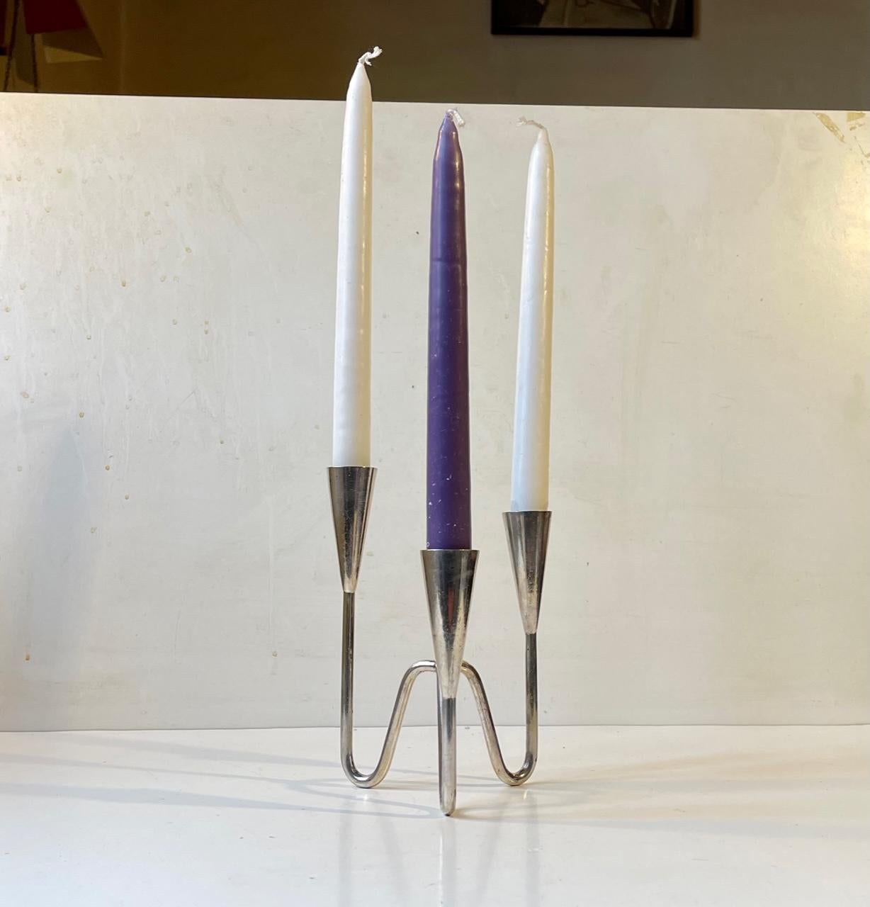 Small silver plated candelabra with tree tiers: 18, 15.5 and 13 cm respectively. Designed and manufactured by Berg in Denmark during the 1960s. It is to bee installed with regular sized candles. The silver plating however is intact. Measurement: H: