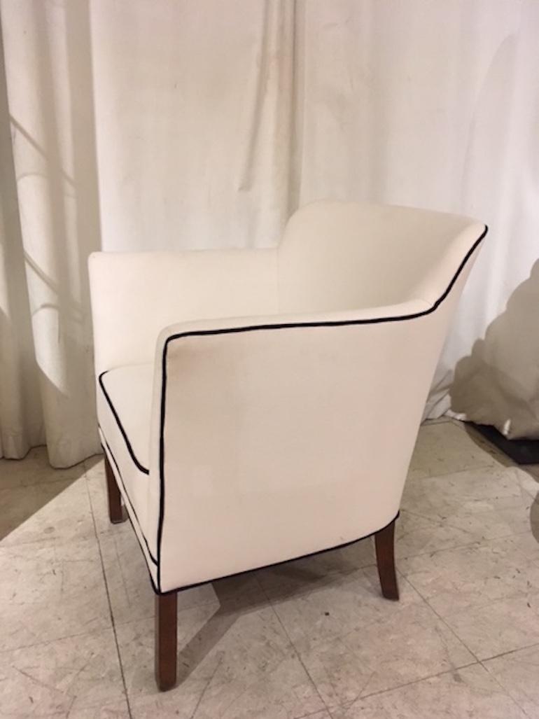 Danish modern single tub armchair upholstered in white linen-cotton with black 
piping.