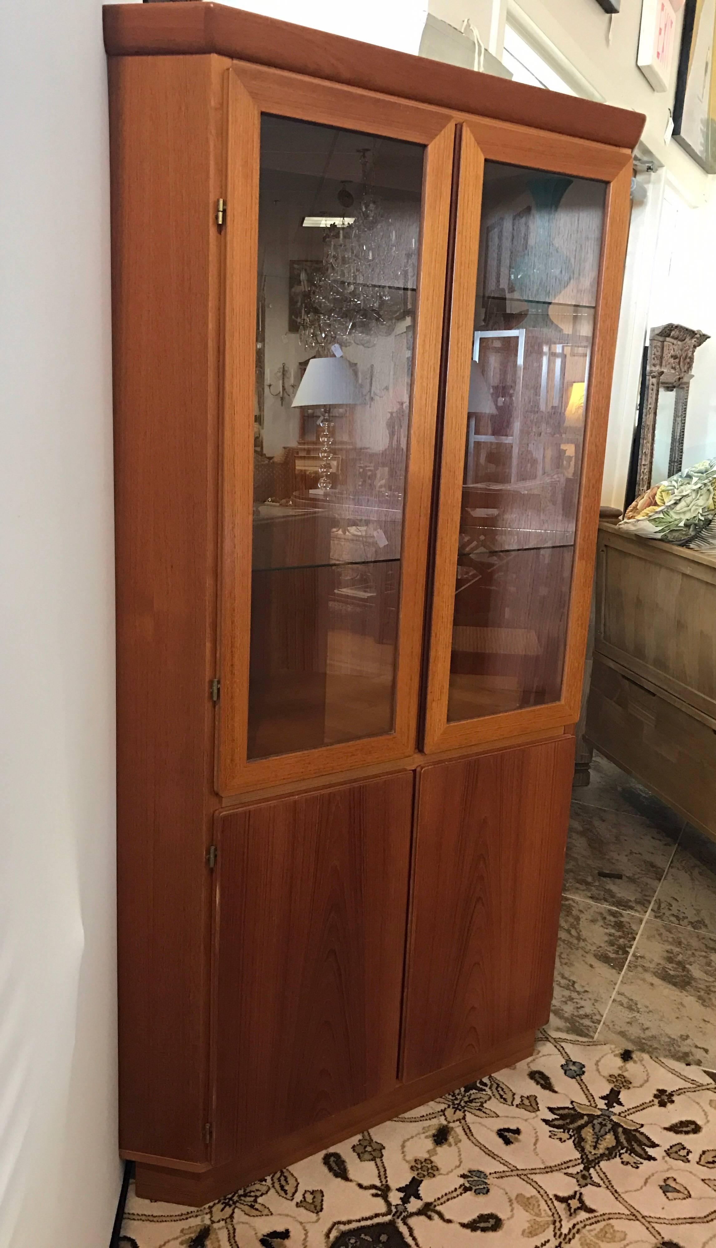 Danish modern signed Skovby Mobelfabrik AS teak corner cabinet with glass doors that open to glass shelves. Bottom part also has two doors that open to shelves. Top part is electrified to light up.