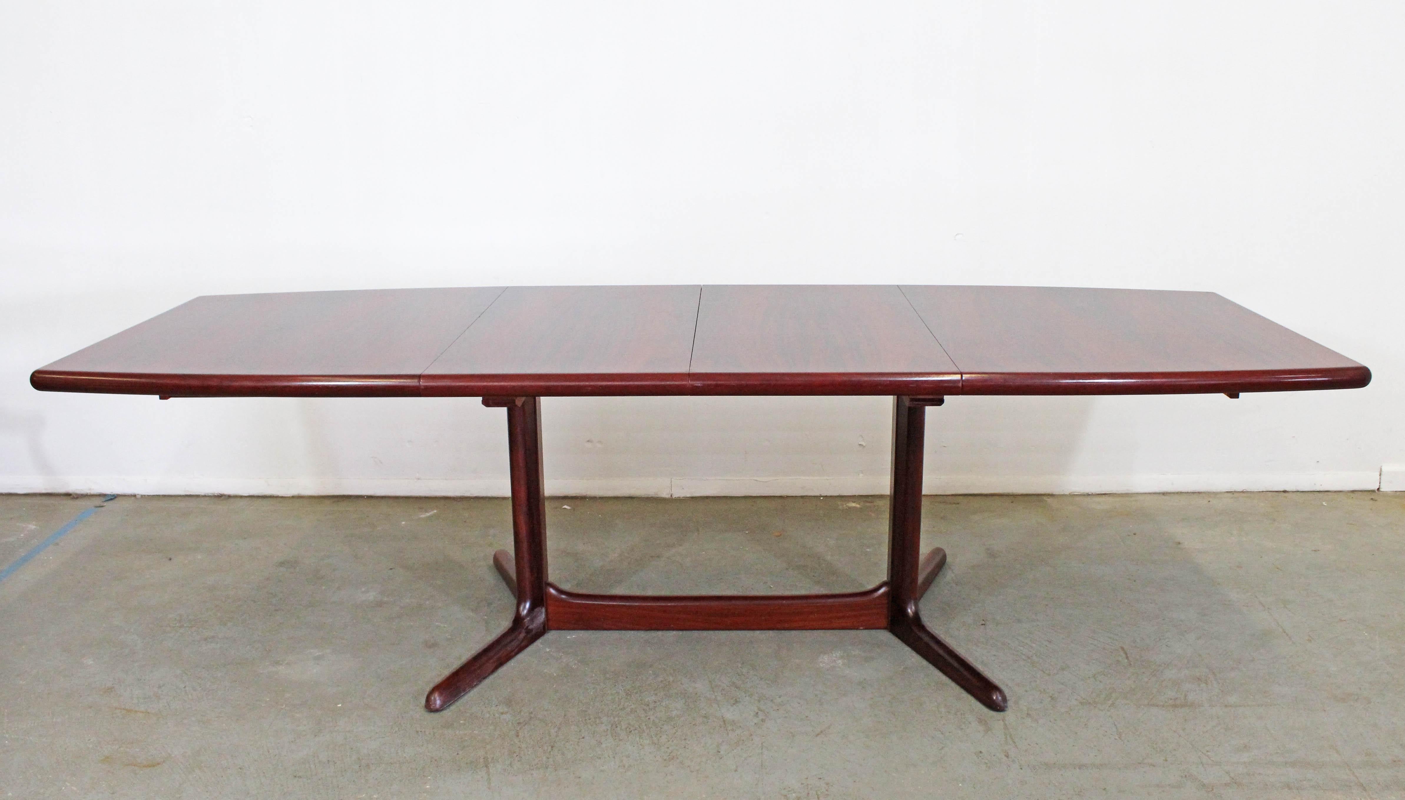 Offered is a beautiful Danish modern extendable dining table with two table leaves. It is made of rosewood and extends out to approximately 104
