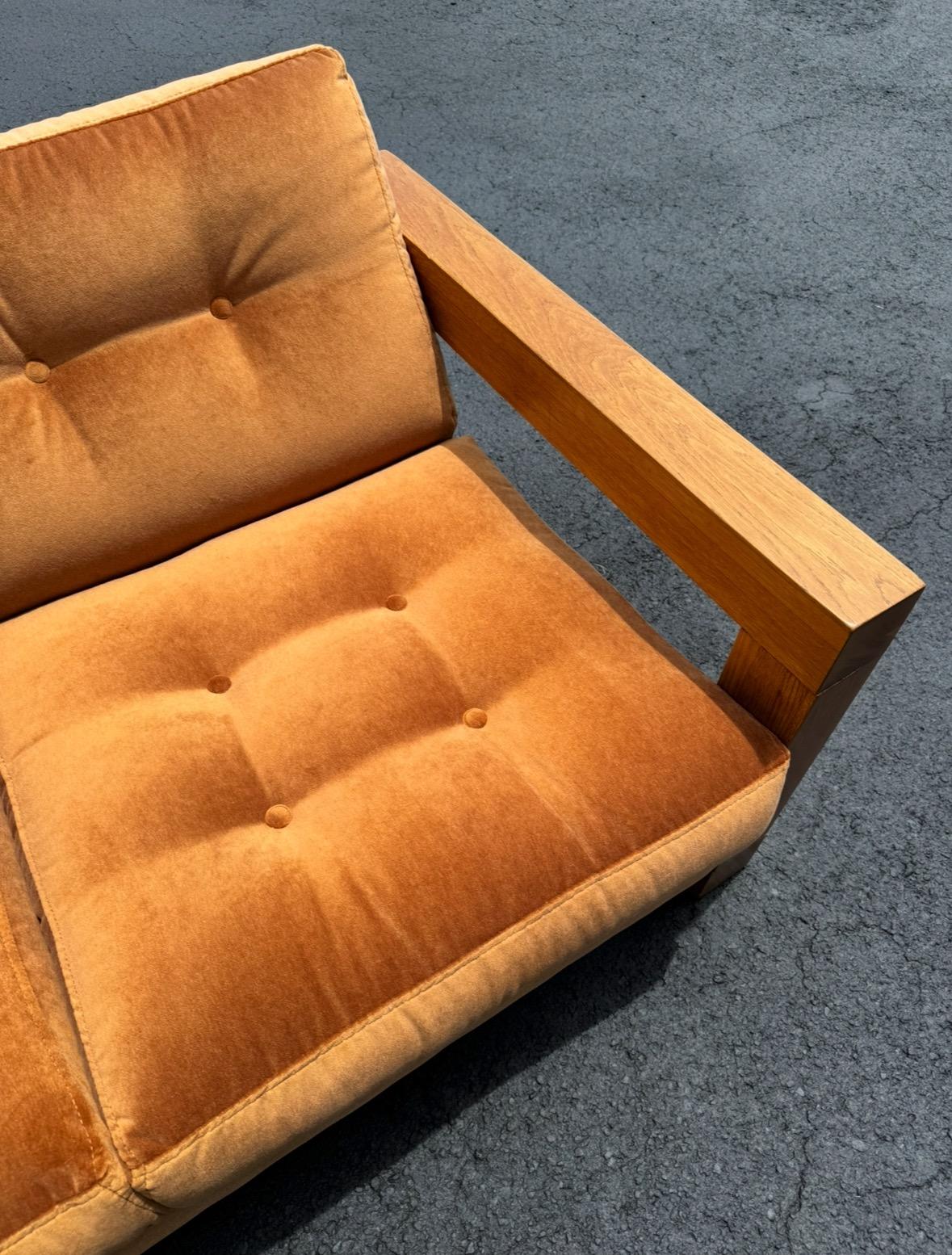 Beautiful Oak Danish Modern loveseat newly upholstered in a Burnt Orange Velvet. This beautiful low profile loveseat is supported by legs made of Oak wood joined at 4 points creating a chunky rectangle frame. The sofa floats effortlessly above the