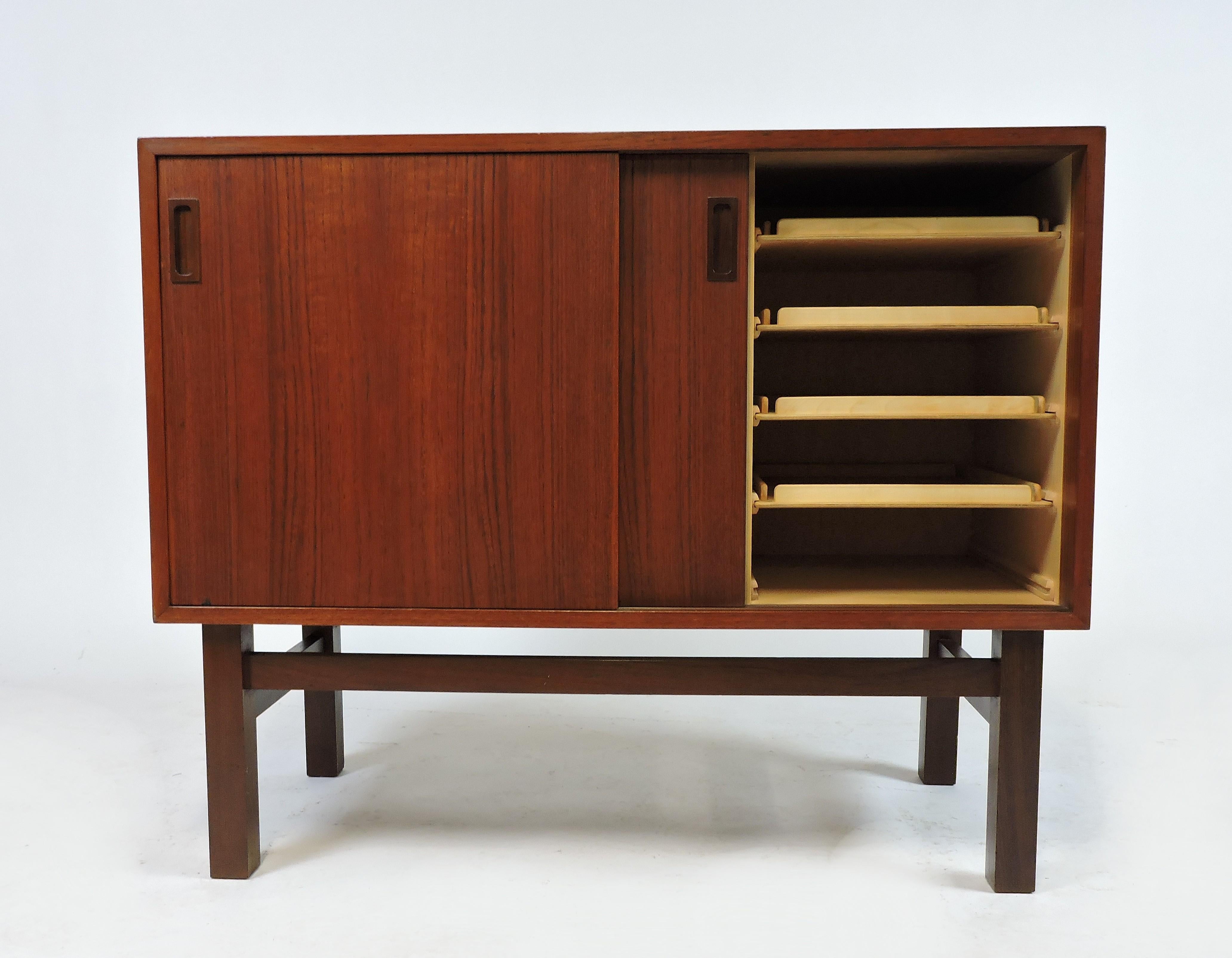 Handsome Danish teak and rosewood credenza from the 1960s. This credenza has storage space that includes 2 compartments with sliding doors. One compartment has an adjustable shelf, the other has 4 pullout / pull-out trays. For contrast, the pulls,