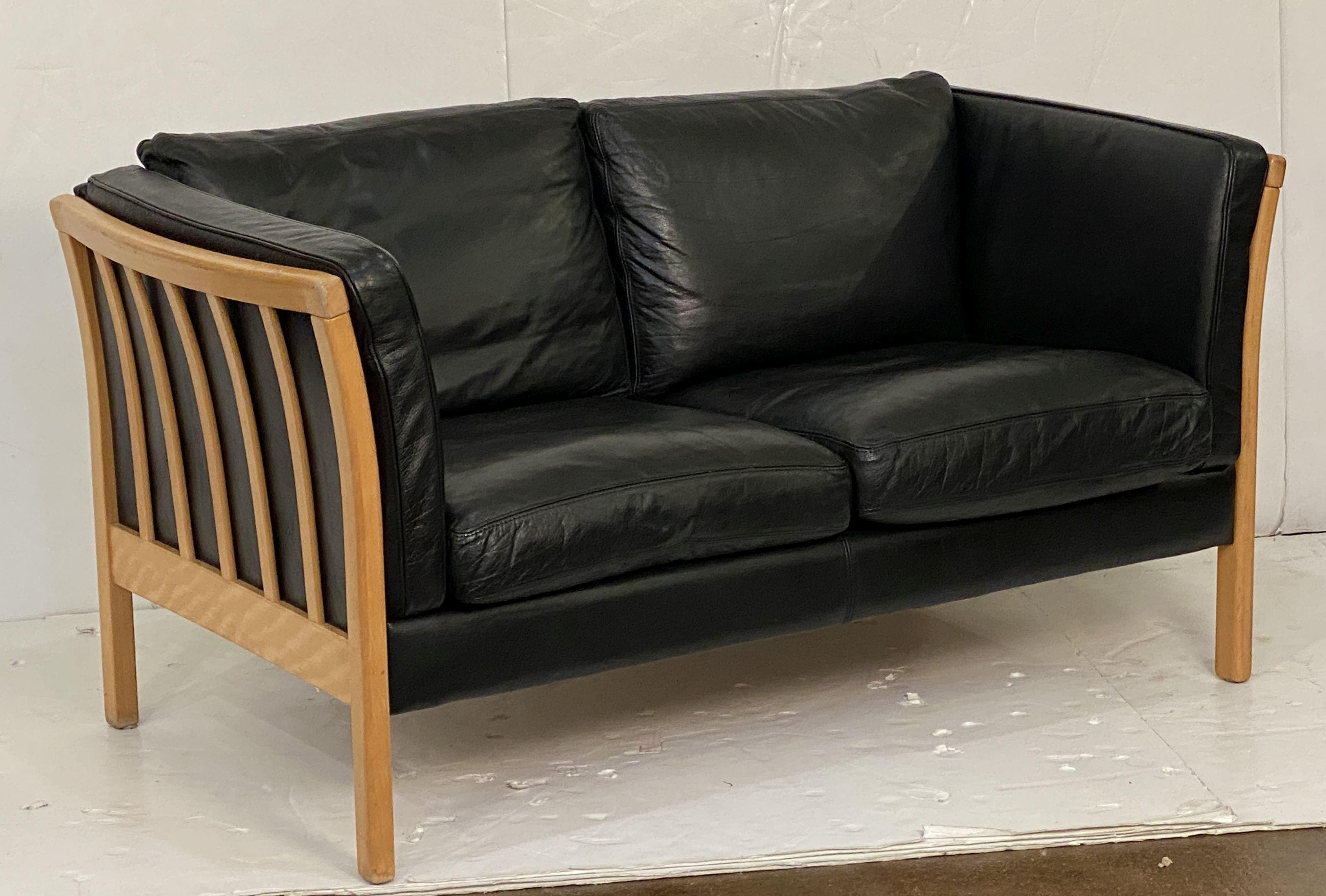 Canapé moderne danois d'époque à deux places en cuir noir et bois de hêtre, au design élégant et raffiné, conçu par le célèbre studio de design Stouby.

Il comprend six coussins (assise, dossier et côtés) sur un cadre rembourré élégant qui offre un