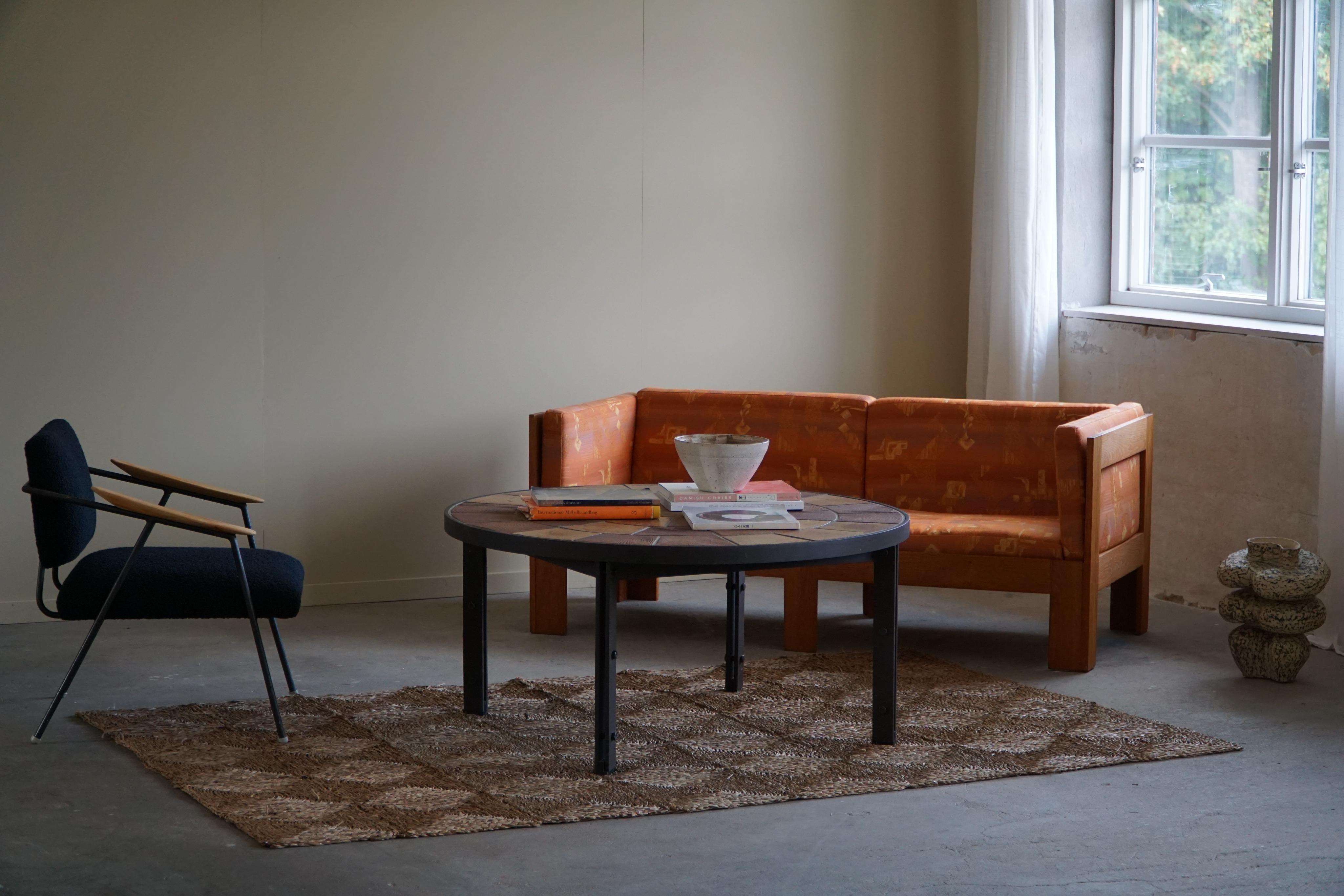 Une magnifique grande table basse ronde / table de canapé avec une structure en acier et des carreaux de céramique faits à la main dans des couleurs terreuses. Fabriqué au Danemark dans les années 1970 par Sallingboe. Conçu par Britt