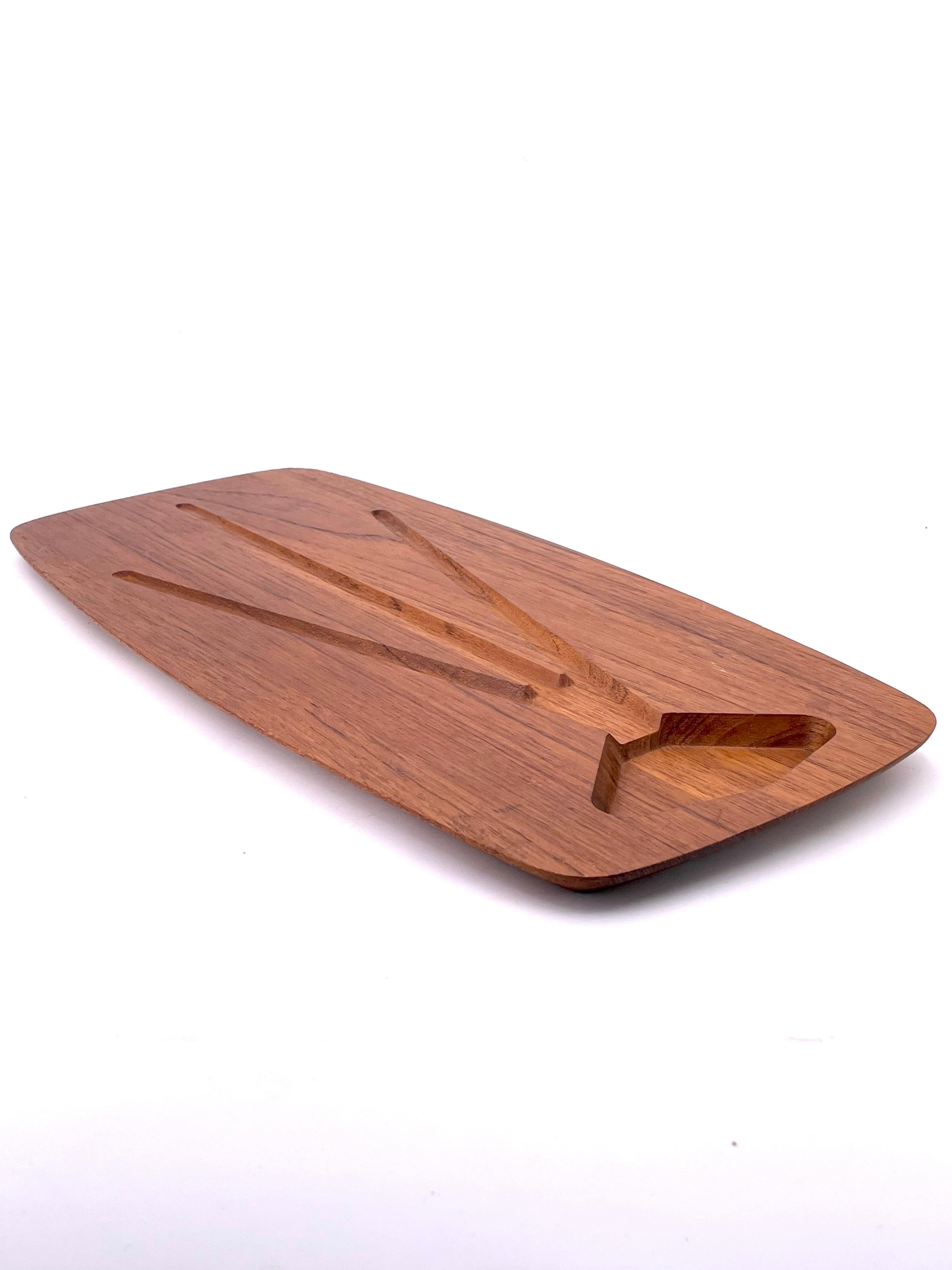 Beautiful solid teak surfboard style carving cutting board, for putting meats and drain the juices. nice beveled edge made in Denmark, circa 1970's by DKF stamped in the back great design and quality.