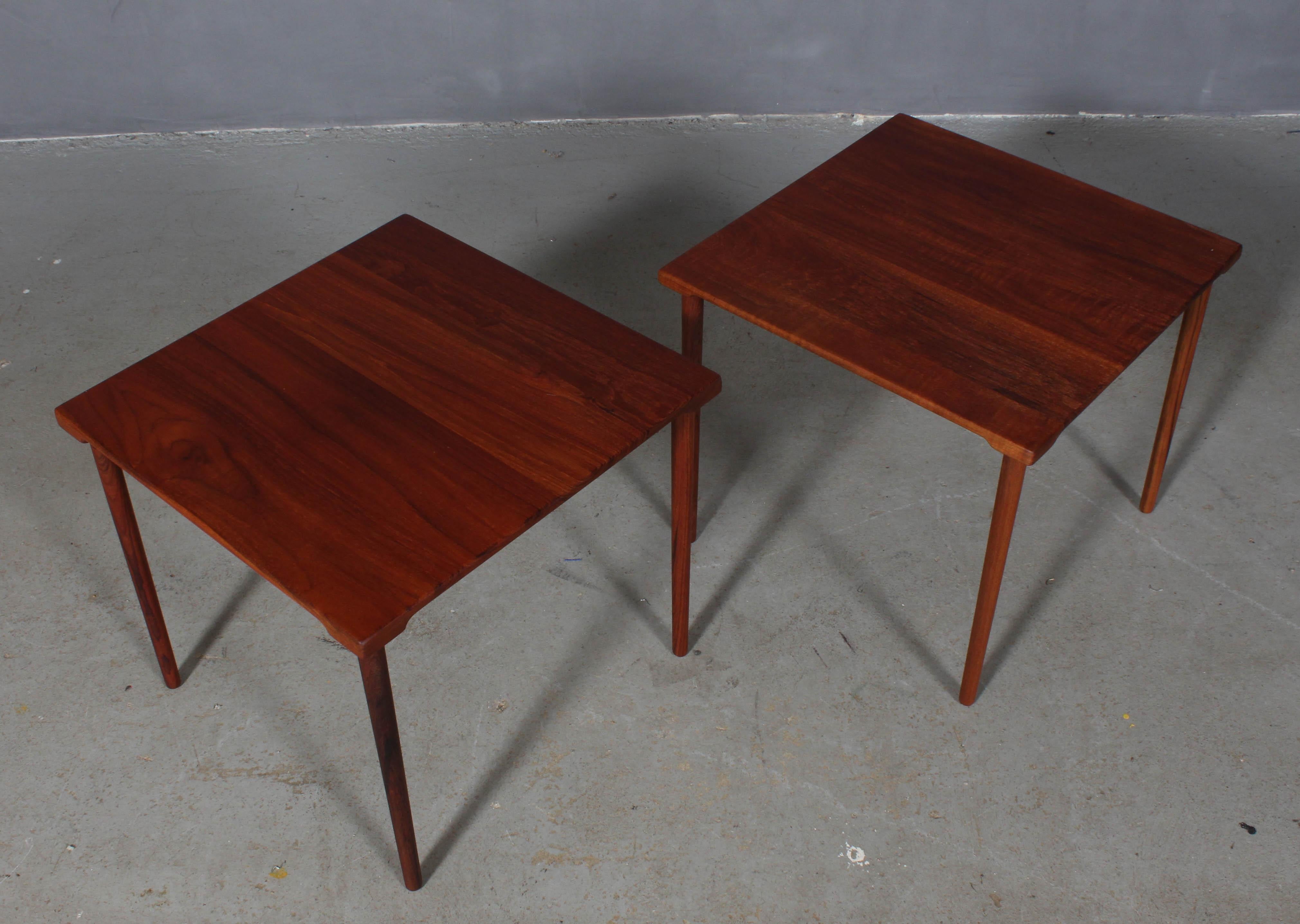These lovely and Minimalist Danish modern teak side tables were designed by Peter Hvidt & Orla Mølgaard-Nielsen in the 1960s for France & Daverkosen / France & Son. Made entirely of solid teak, the top has gorgeous grain, and each side has an arced